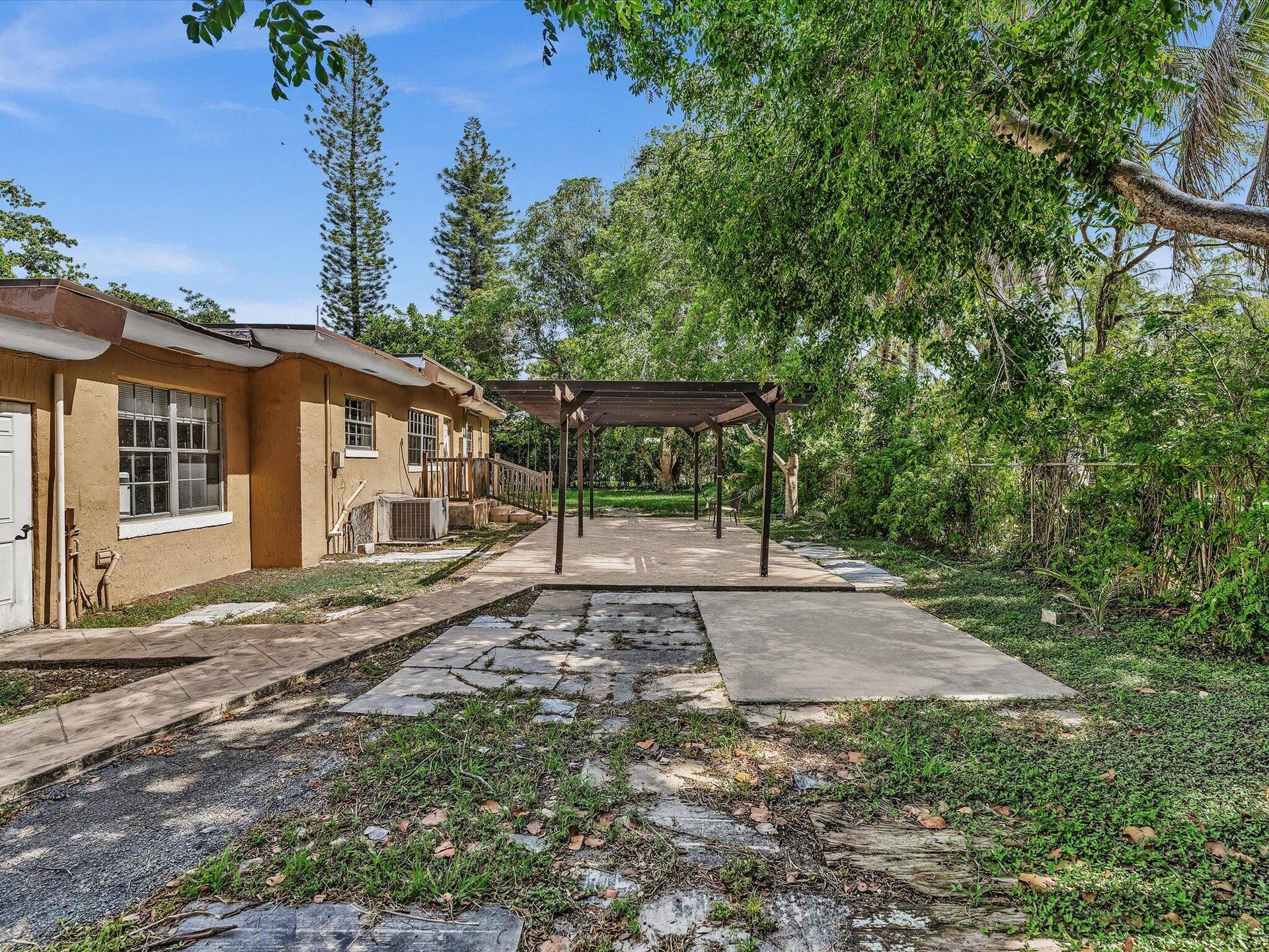 Spacious exterior patio featuring a wooden pergola