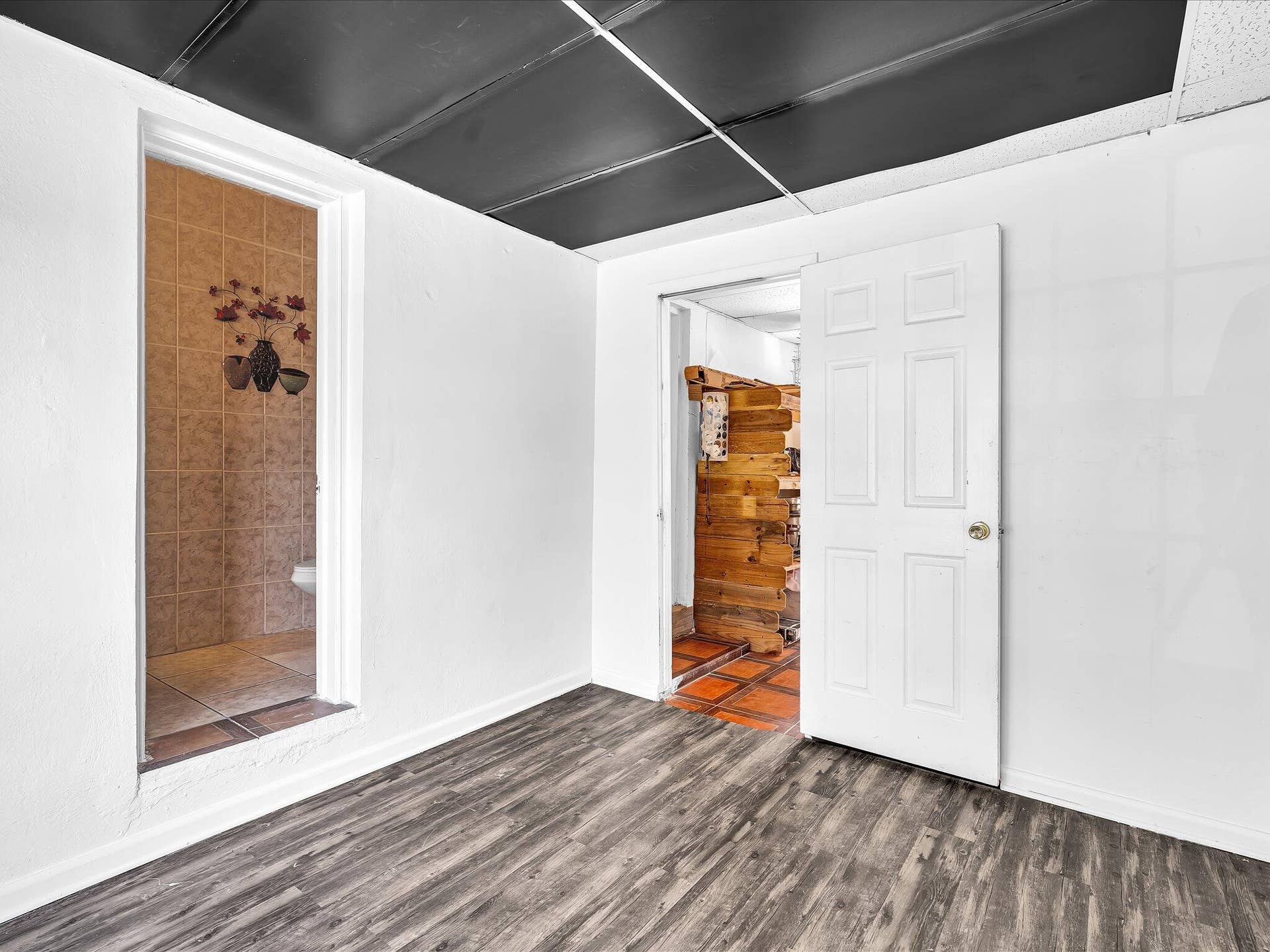Spacious room featuring wood-finish flooring and white walls