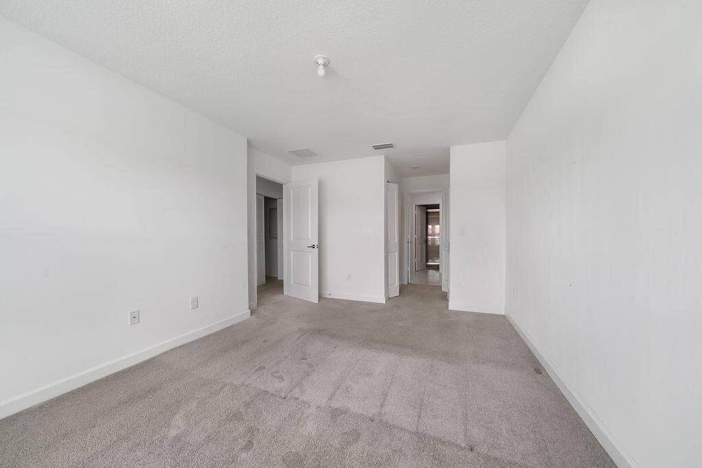 Carpeted room featuring white painted walls and a textured ceiling