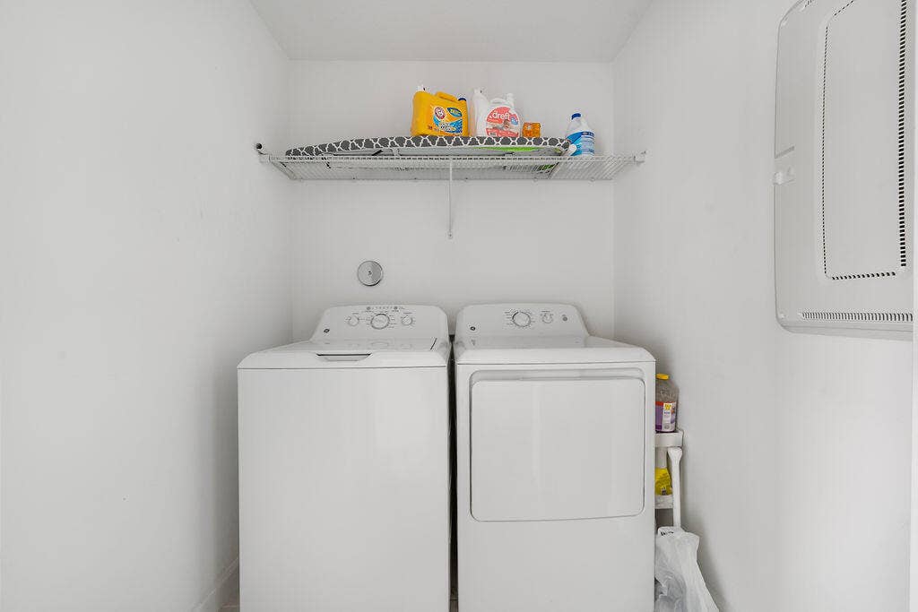 Dedicated laundry area featuring a white top-load washing machine and a white front-load dryer