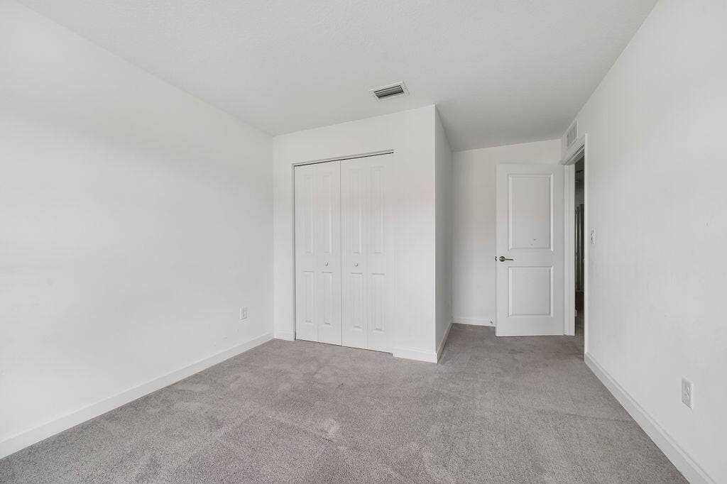 Interior room featuring neutral white walls and gray carpeting
