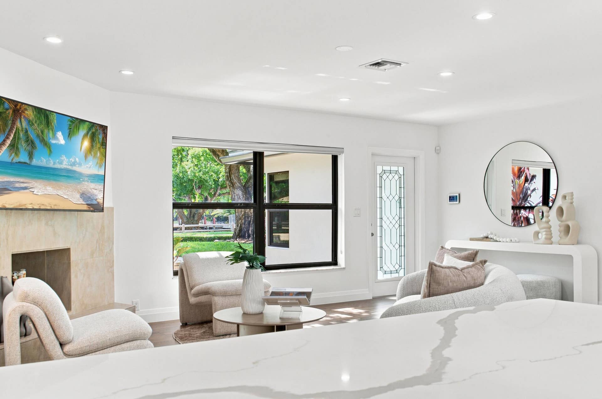 Living area featuring recessed lighting, a stone-clad fireplace, and large windows with outdoor views