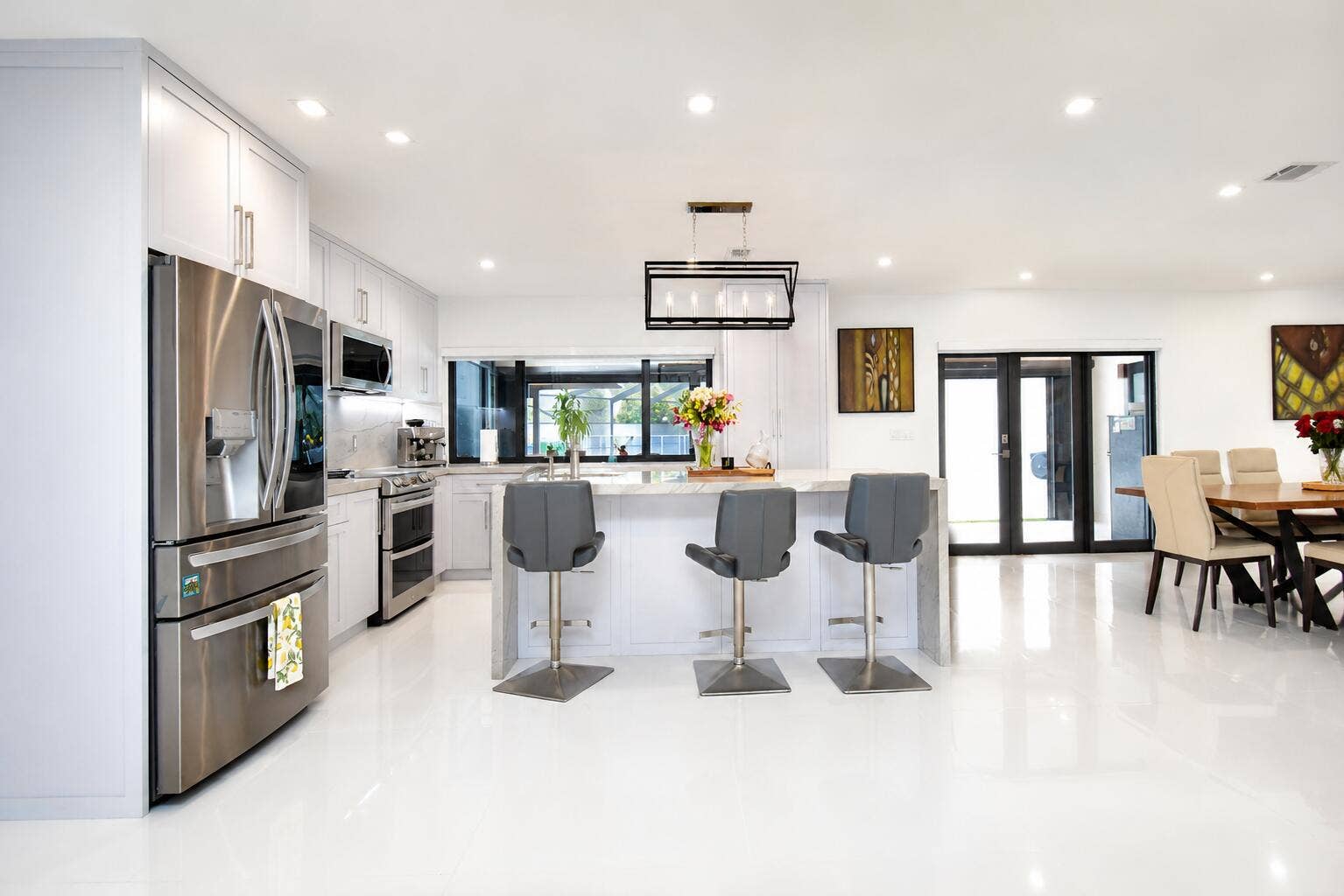 5061 SW 87TH Terrace, Cooper City, FL 33328 Expansive kitchen featuring white cabinetry, stainless steel appliances, a center island with pendant lighting, and polished white flooring