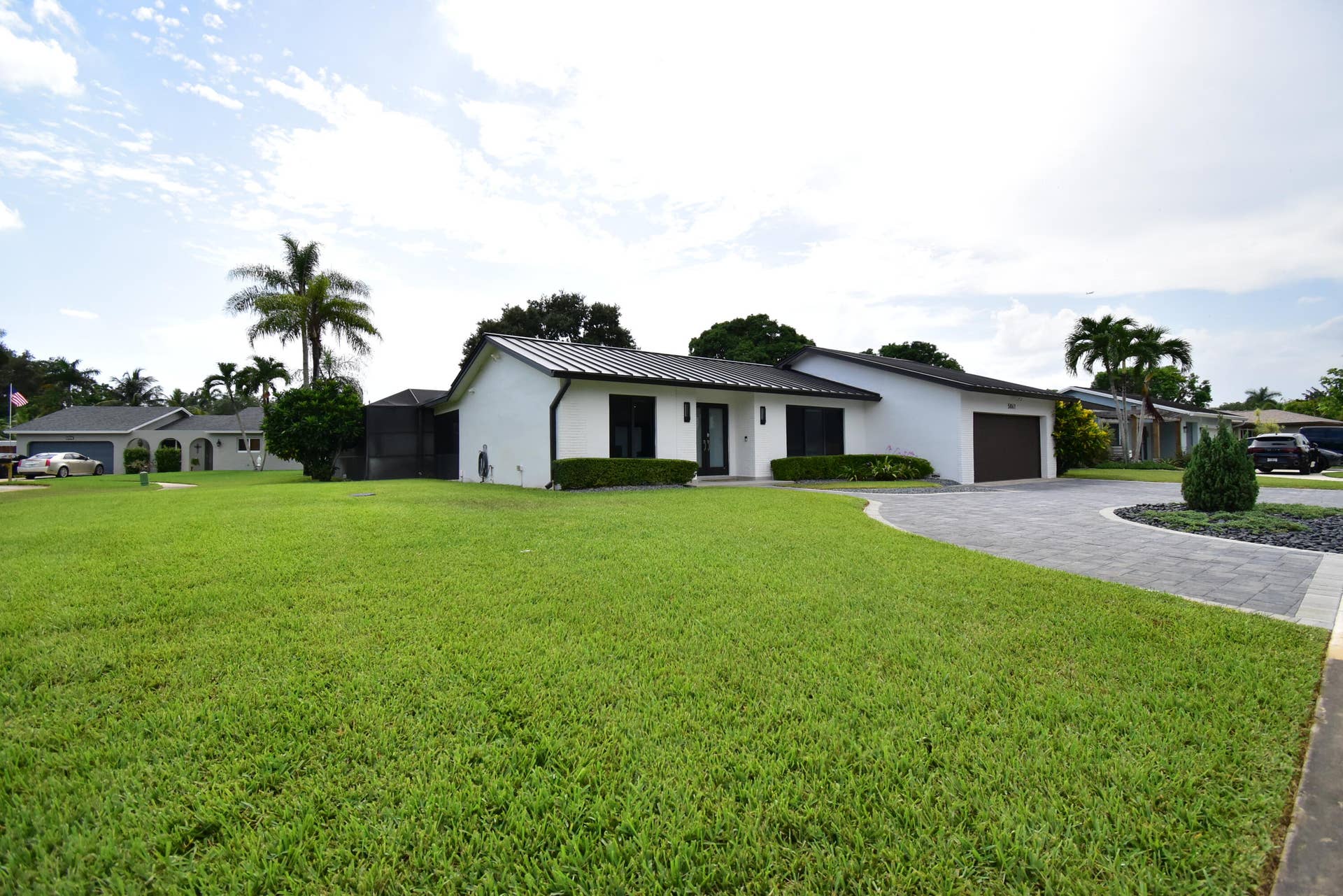 5061 SW 87TH Terrace, Cooper City, FL 33328 Contemporary single-story residence with a dark metal roof and white exterior