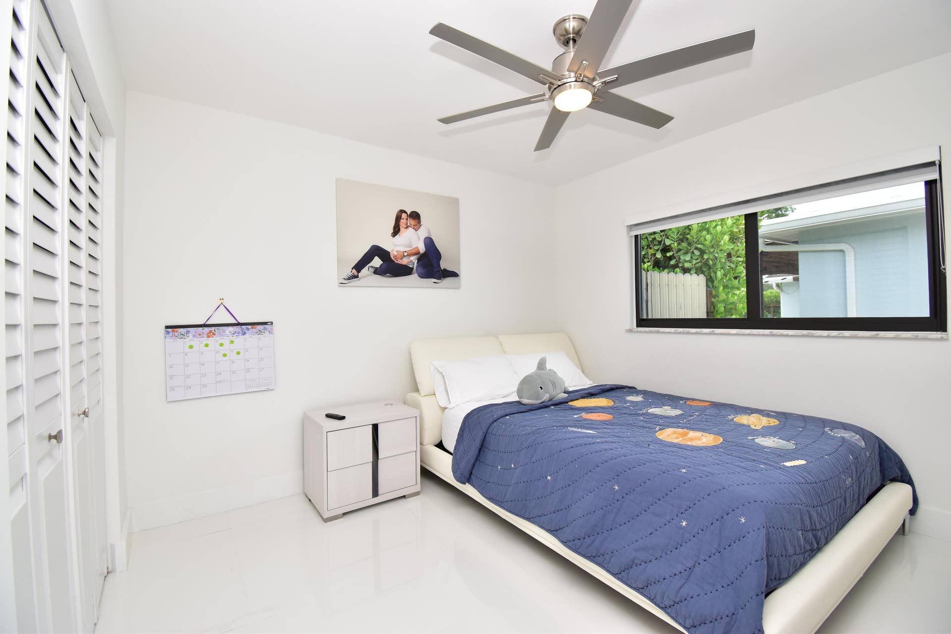 5061 SW 87TH Terrace, Cooper City, FL 33328 Bright interior space featuring a ceiling fan with integrated lighting, a horizontal window with exterior landscaping visible, and louvered closet doors
