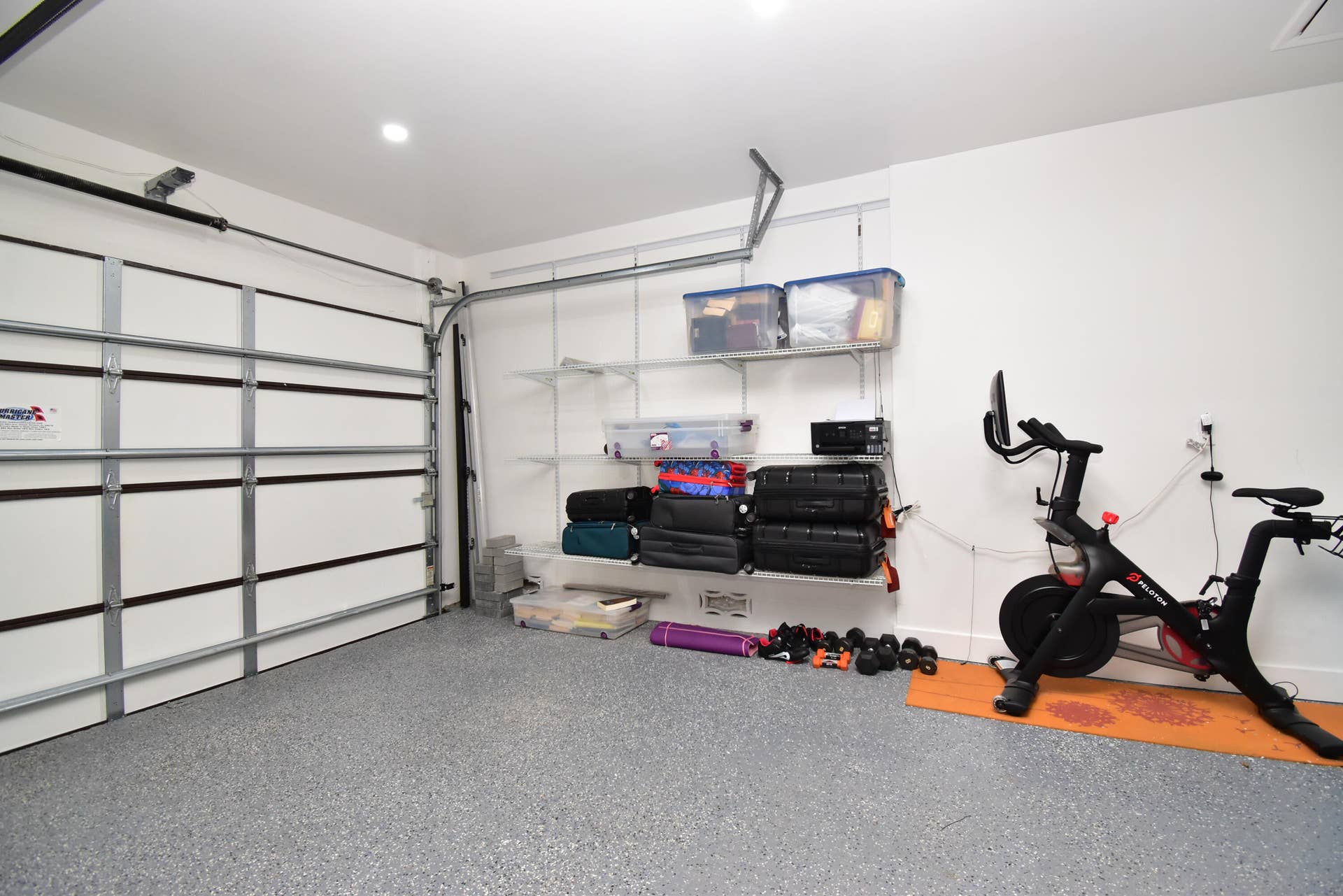 5061 SW 87TH Terrace, Cooper City, FL 33328 Garage space featuring a speckled epoxy floor, white walls, and a paneled garage door