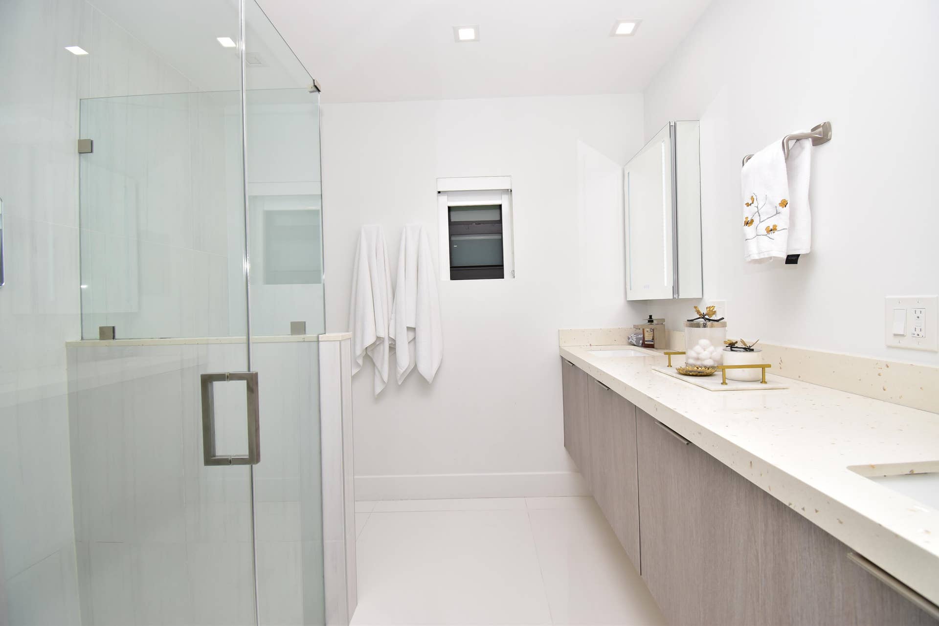 5061 SW 87TH Terrace, Cooper City, FL 33328 Modern bathroom featuring a frameless glass shower enclosure, a floating vanity with wood-finish cabinetry, a light-toned countertop, and recessed ceiling lighting