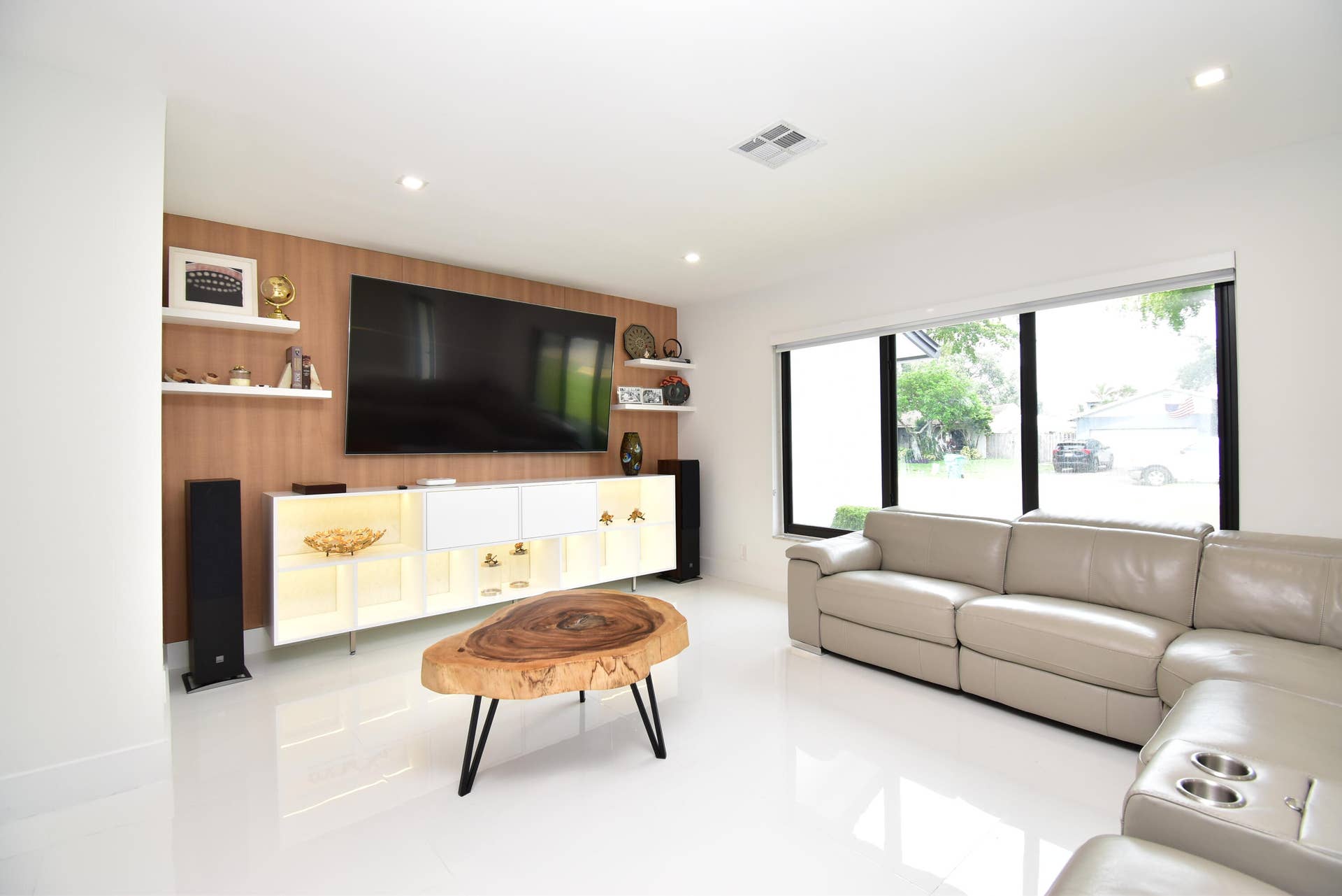 5061 SW 87TH Terrace, Cooper City, FL 33328 Living space featuring white polished flooring, a large multi-pane window, recessed lighting, and a wood-finish accent wall with floating shelves