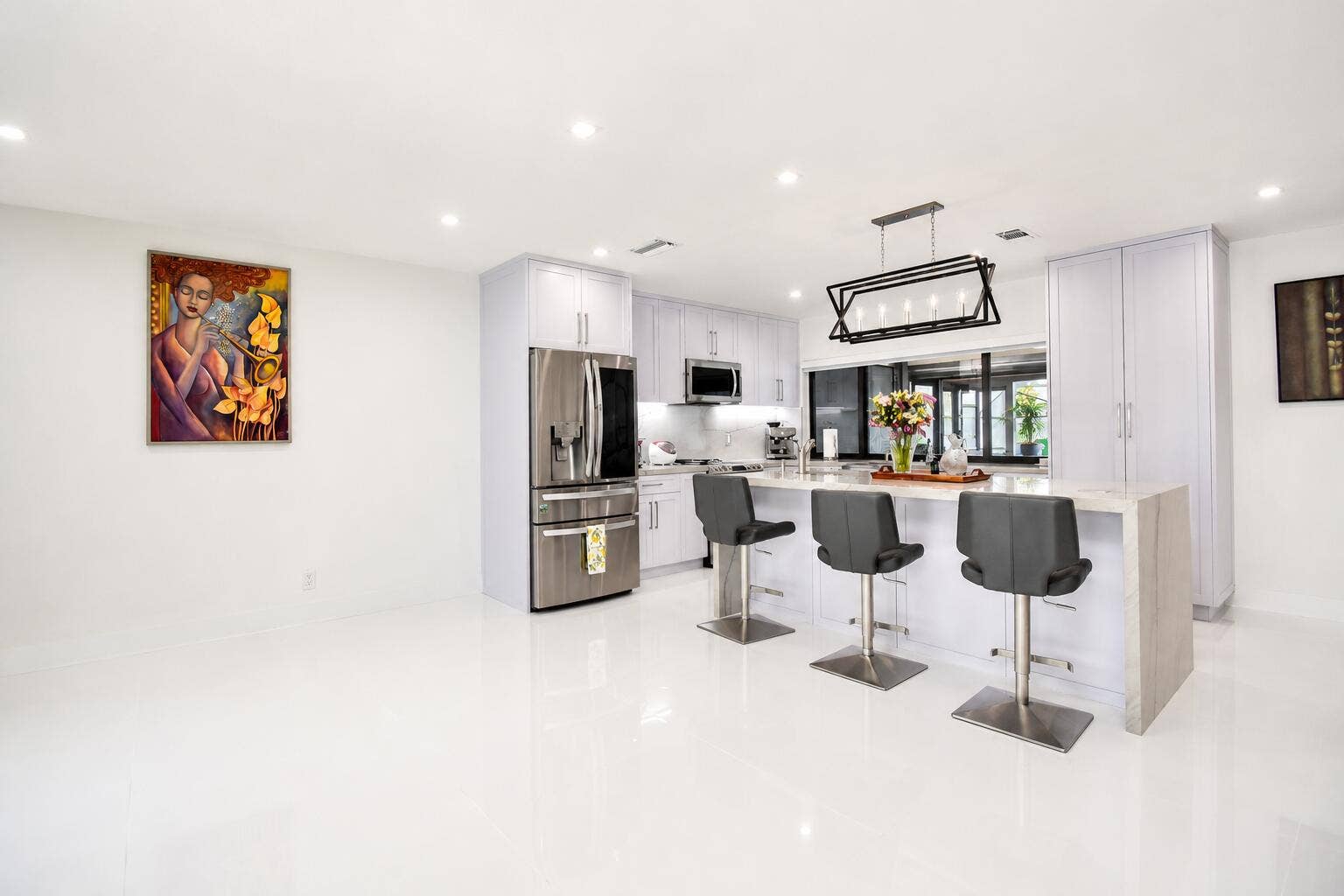 5061 SW 87TH Terrace, Cooper City, FL 33328 Modern kitchen featuring white cabinetry, stainless steel appliances, and a central island with countertop seating