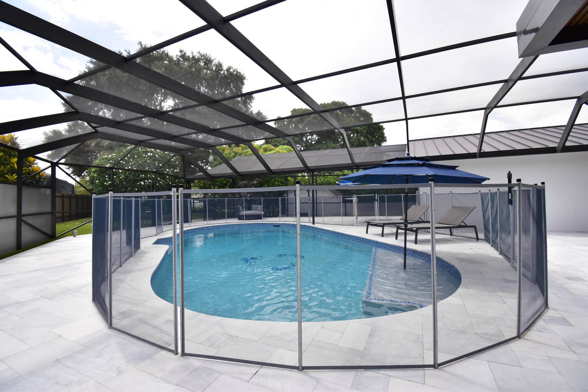 5061 SW 87TH Terrace, Cooper City, FL 33328 Screened-in pool area featuring a curved swimming pool, tiled pool interior, and perimeter safety fencing