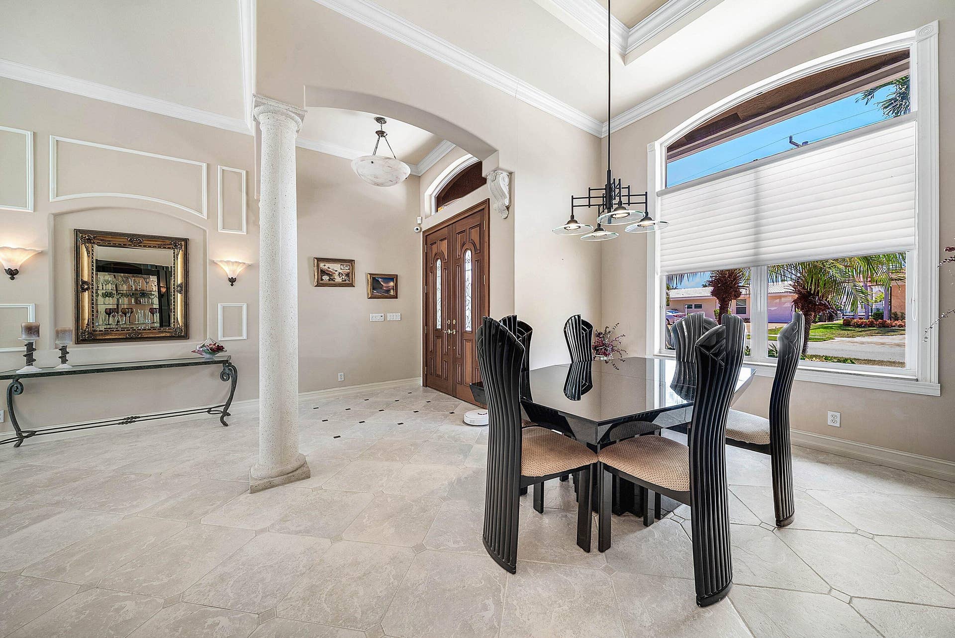 2761 NE 48TH Court, Lighthouse Point, FL 33064 Vaulted ceiling foyer featuring a custom double wood-paneled door, decorative wall paneling, and an arched entryway