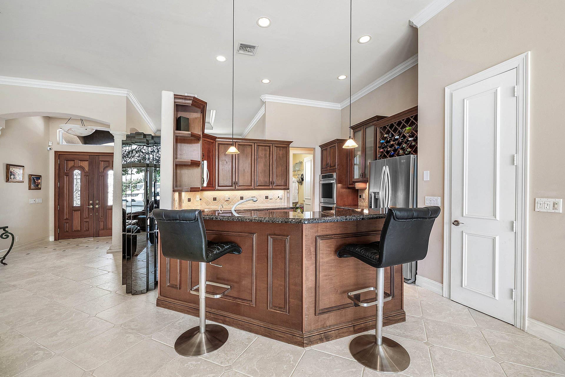 2761 NE 48TH Court, Lighthouse Point, FL 33064 Kitchen featuring a granite-topped island with wood paneling, recessed lighting, and tile flooring