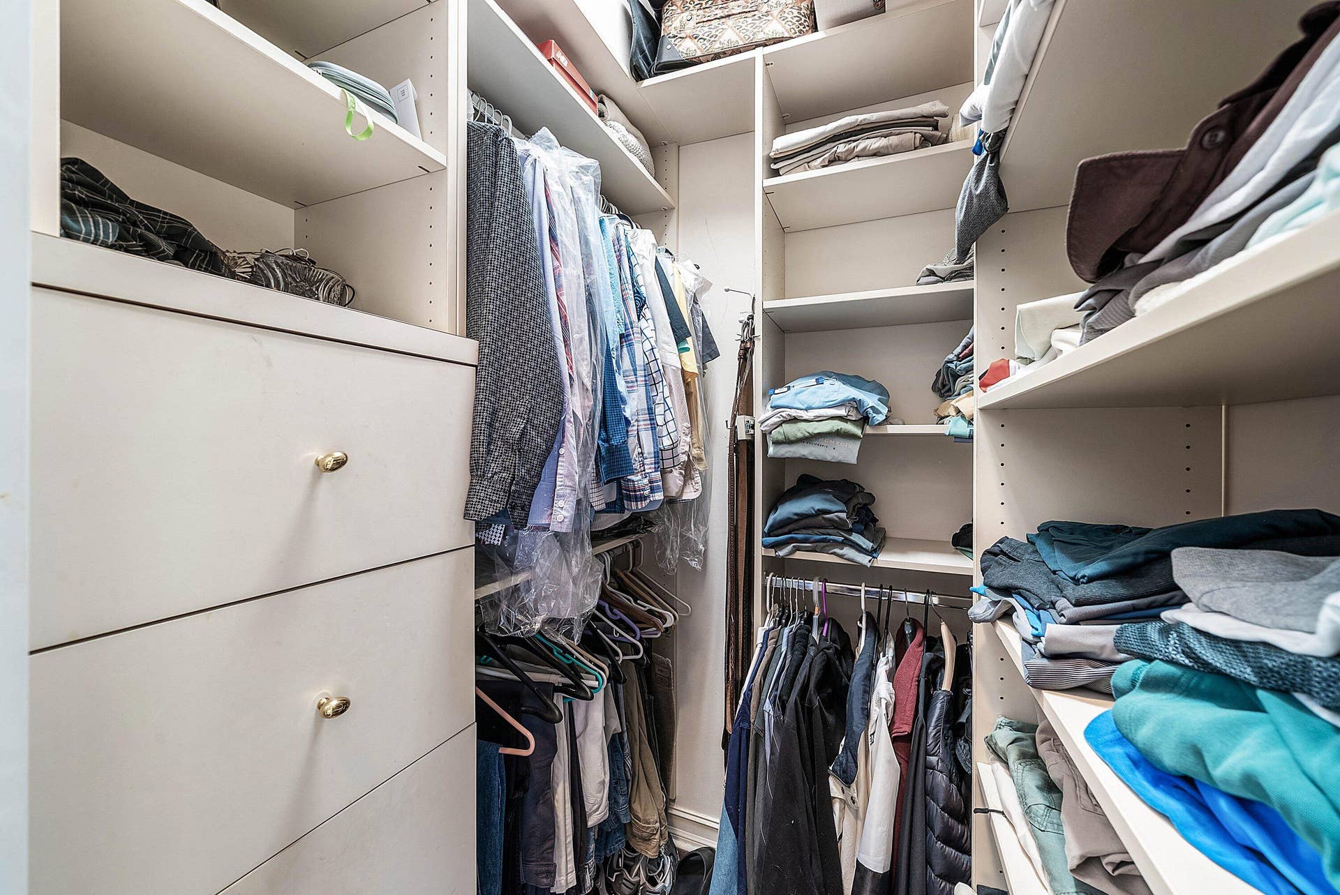 2761 NE 48TH Court, Lighthouse Point, FL 33064 Built-in closet system featuring white shelving and drawer units with gold-tone hardware, providing extensive storage options
