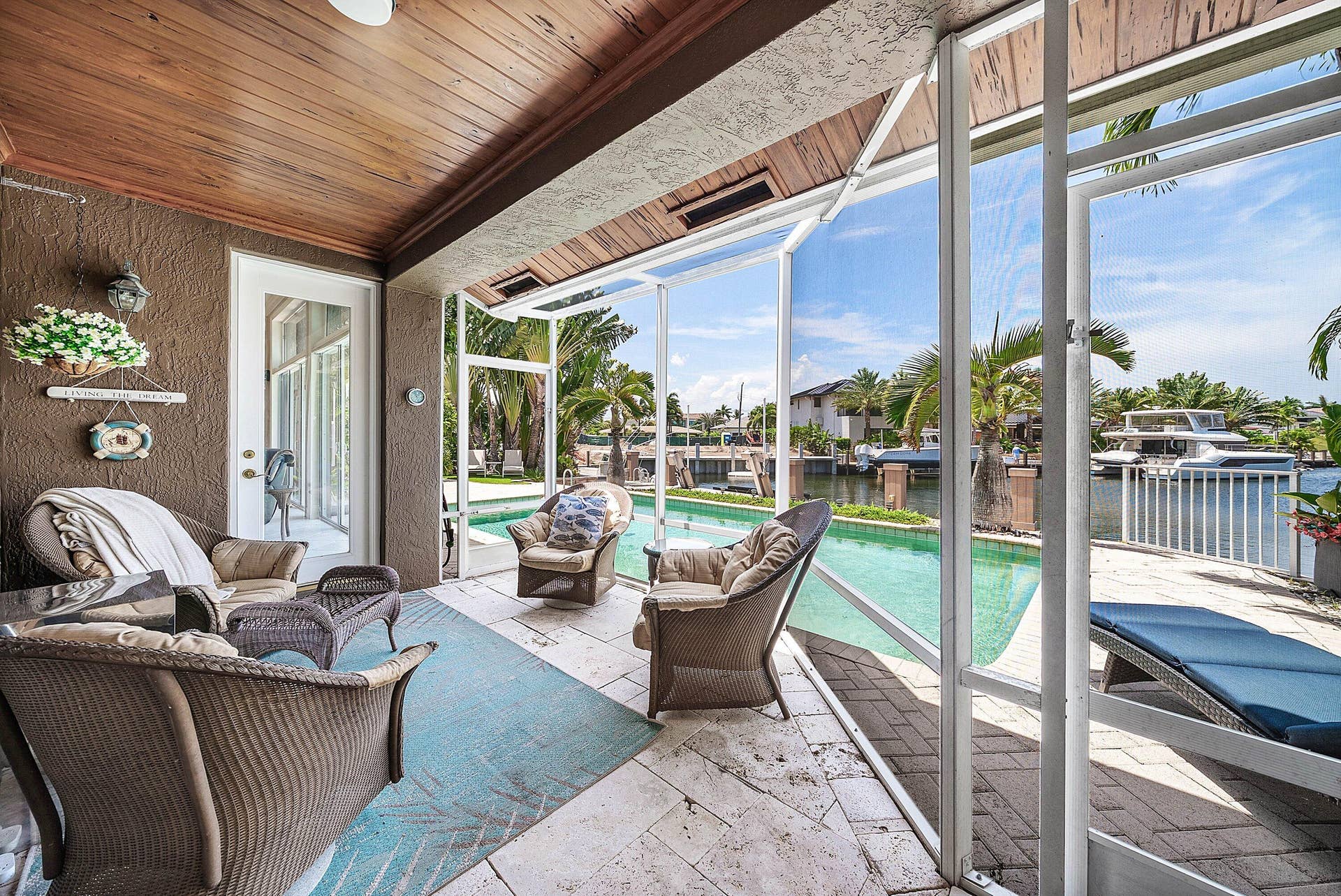 2761 NE 48TH Court, Lighthouse Point, FL 33064 Screened lanai featuring a wood-finish tongue-and-groove ceiling, tiled flooring, and direct access to the outdoor pool area