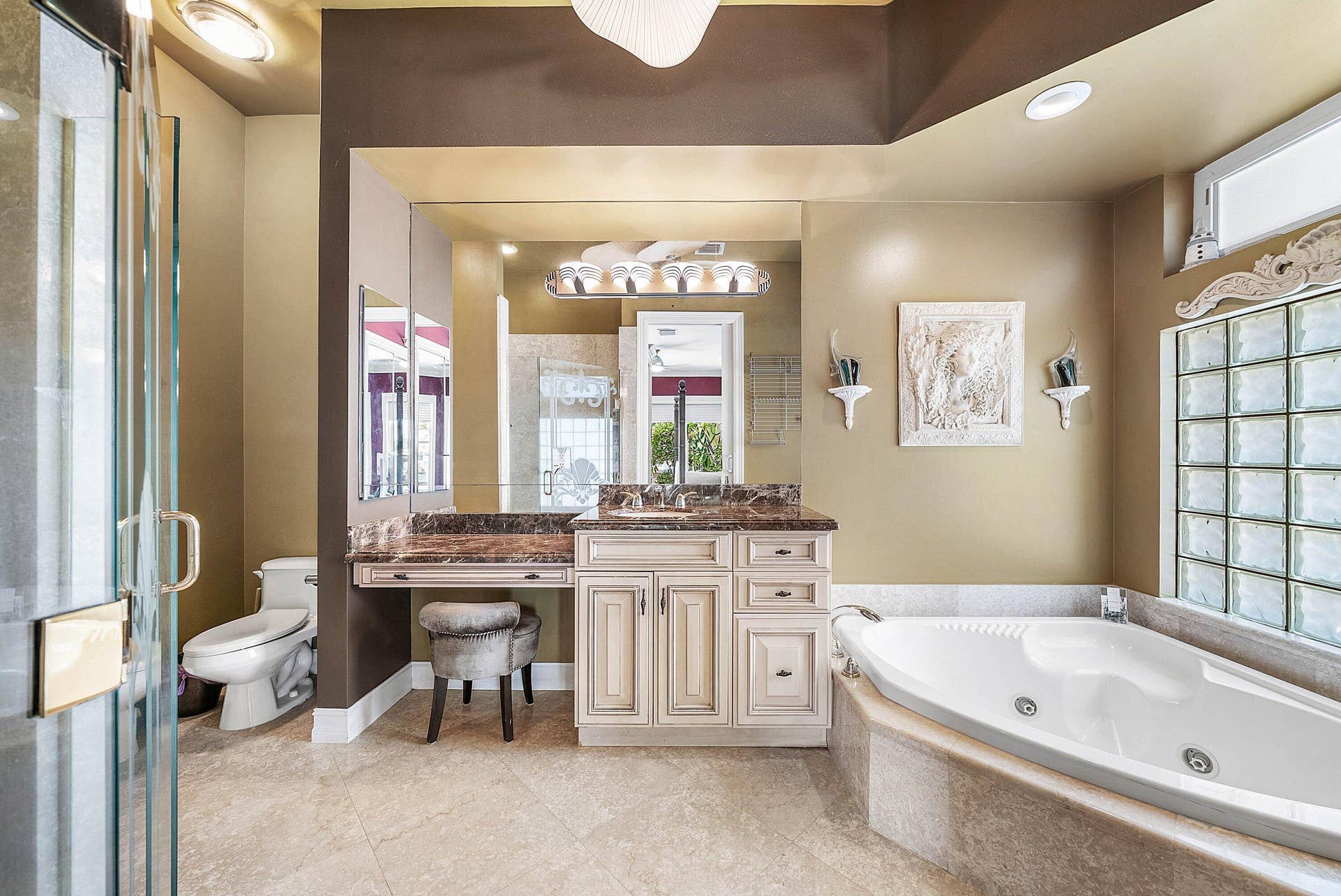 2761 NE 48TH Court, Lighthouse Point, FL 33064 Spacious bathroom featuring a large jetted soaking tub, glass block window, and a separate glass-enclosed shower