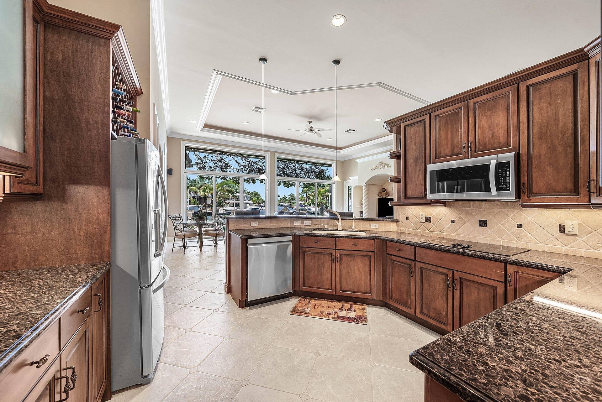 2761 NE 48TH Court, Lighthouse Point, FL 33064 Kitchen featuring wood cabinetry, stainless steel appliances, and granite-style countertops