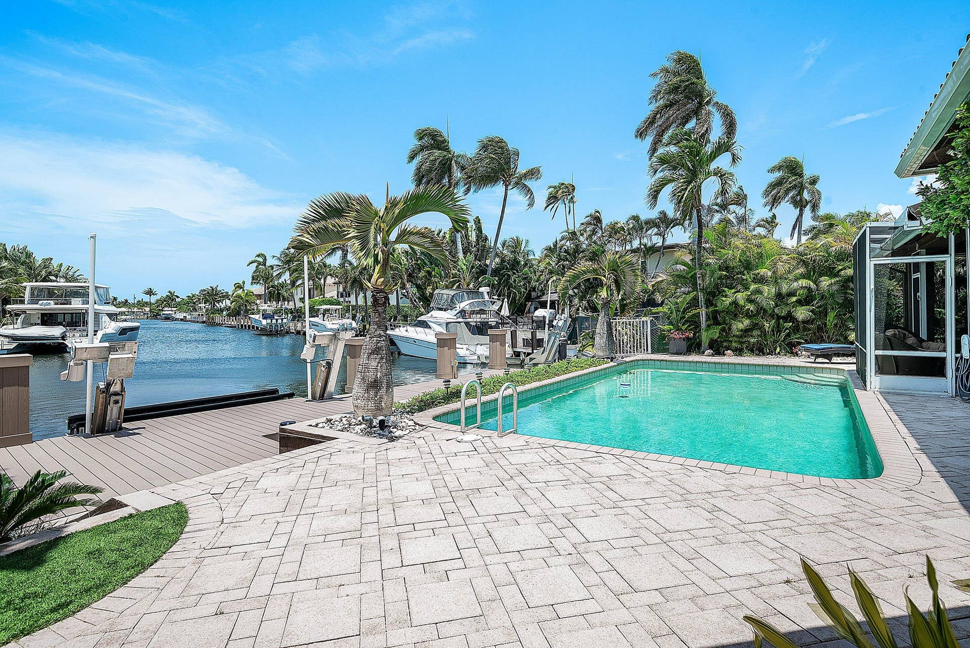 2761 NE 48TH Court, Lighthouse Point, FL 33064 Waterfront property featuring a private swimming pool, paver patio, and composite decking with dual boat lifts