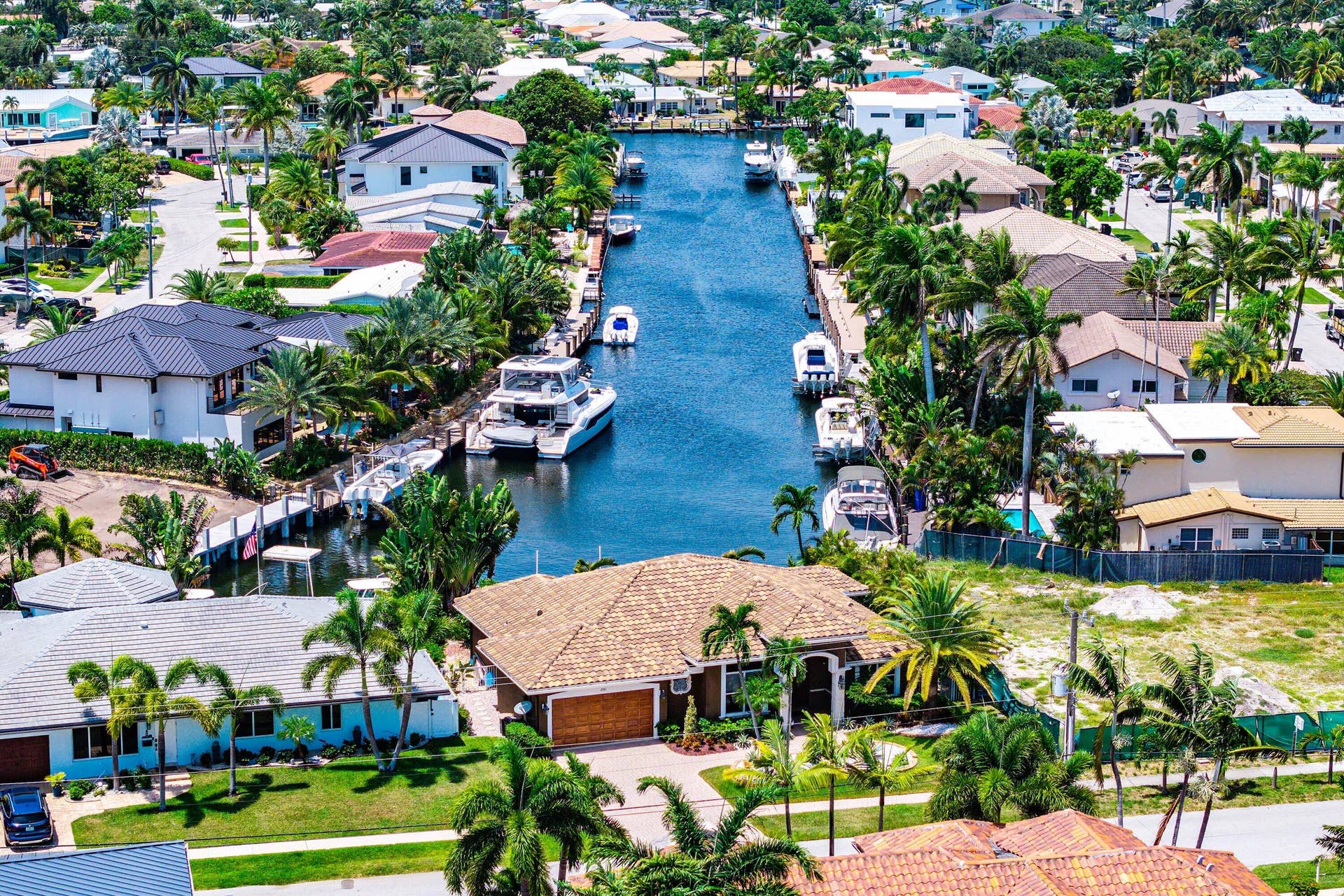 2761 NE 48TH Court, Lighthouse Point, FL 33064 Waterfront properties featuring private boat docks, mature palm landscaping, and paved streets