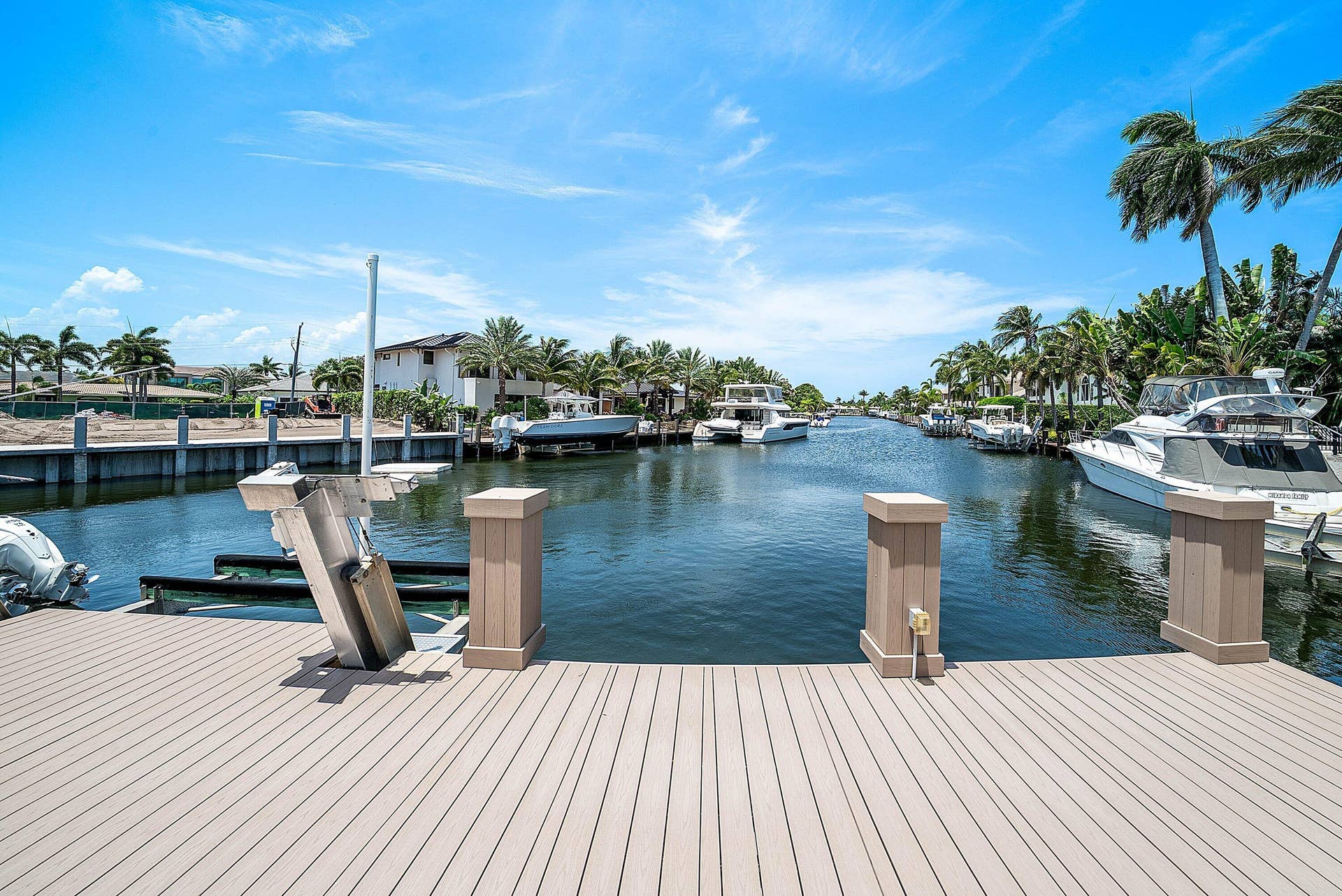2761 NE 48TH Court, Lighthouse Point, FL 33064 Waterfront property featuring a composite deck, an installed boat lift, and palm trees