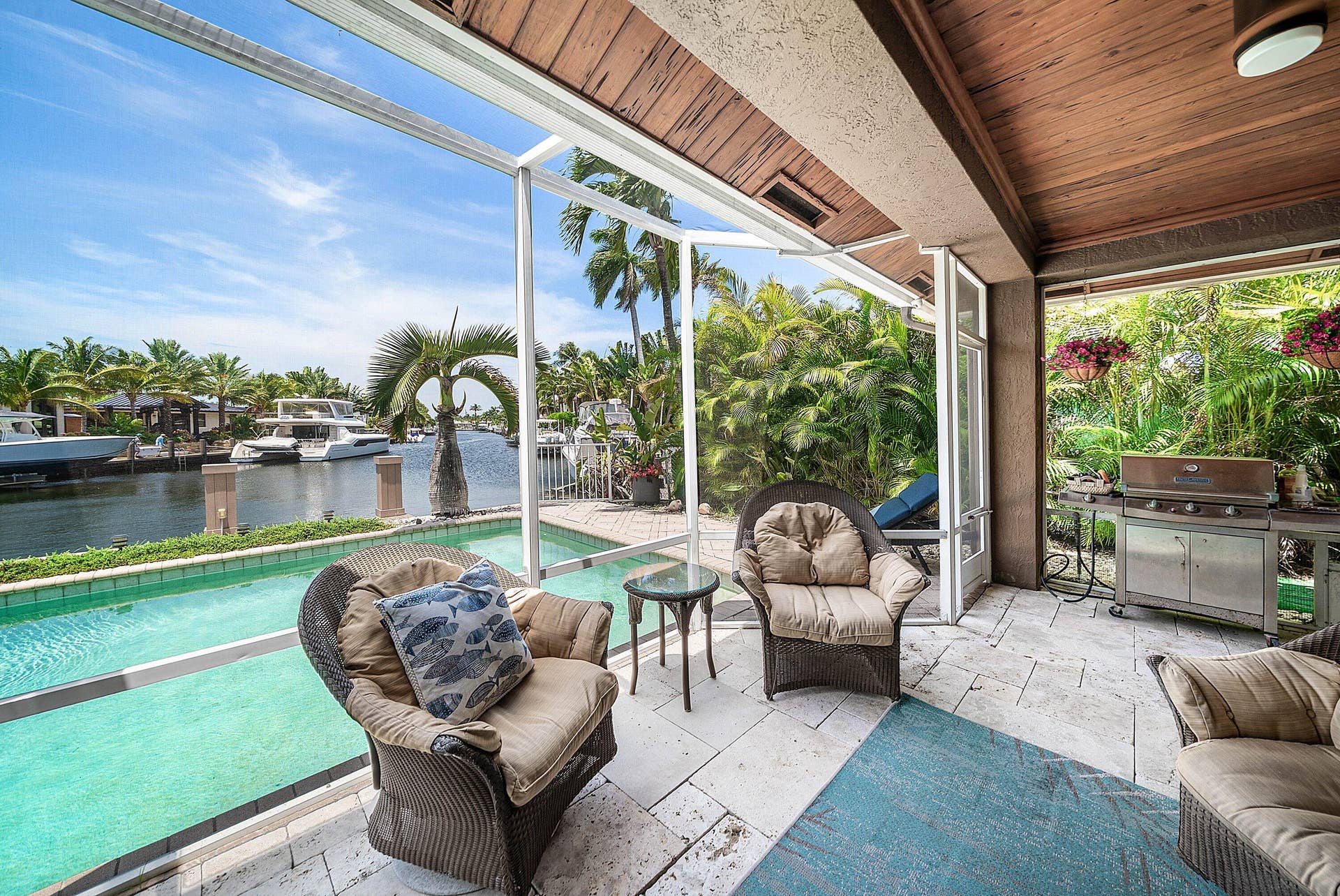 2761 NE 48TH Court, Lighthouse Point, FL 33064 Screened patio with a wood-finish ceiling, stone tile flooring, and a built-in outdoor grill
