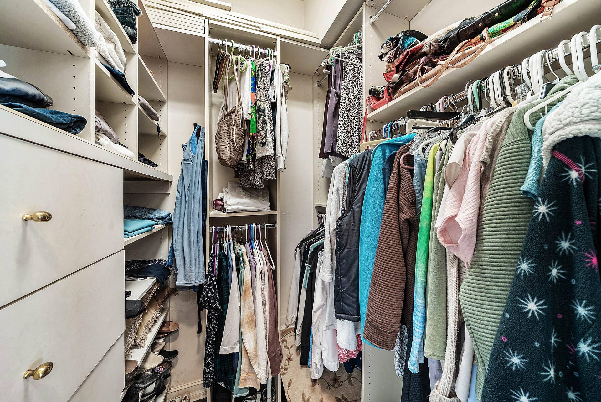 2761 NE 48TH Court, Lighthouse Point, FL 33064 Custom closet system featuring multiple hanging rods, built-in shelving, and drawers with gold-tone hardware