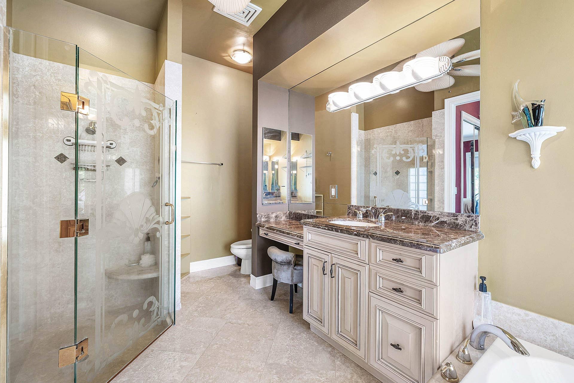 2761 NE 48TH Court, Lighthouse Point, FL 33064 Spacious bathroom featuring a glass-enclosed shower with decorative etching, integrated bench, and tiled walls