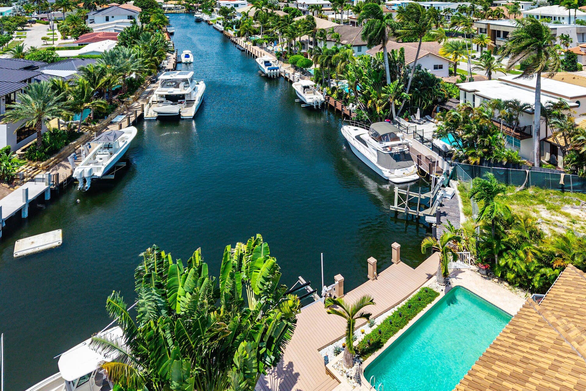 2761 NE 48TH Court, Lighthouse Point, FL 33064 Waterfront property featuring a private boat dock, an in-ground swimming pool, and a spacious pool deck