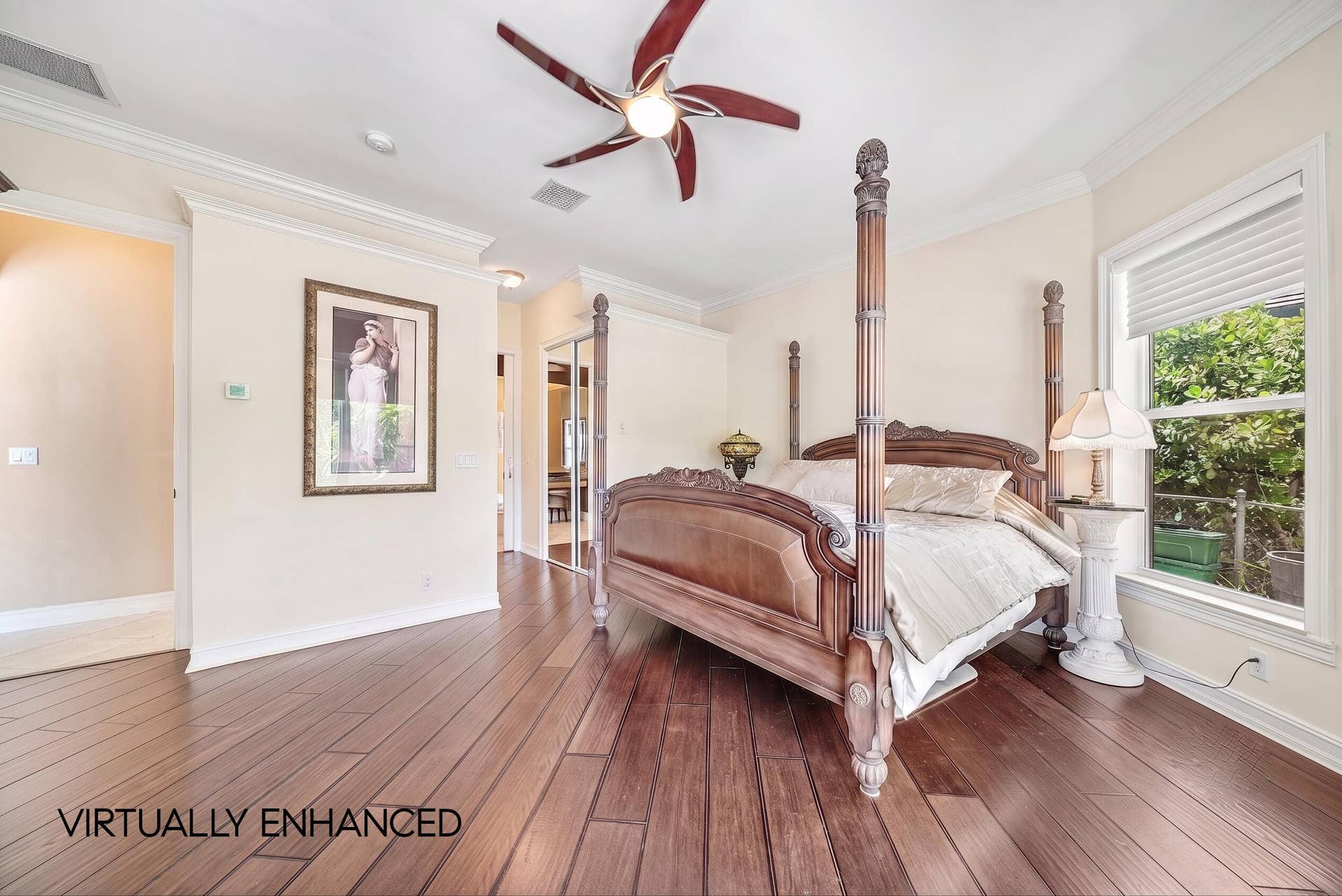 2761 NE 48TH Court, Lighthouse Point, FL 33064 Spacious bedroom featuring rich wood-finish flooring, crown molding, and a ceiling fan with integrated lighting