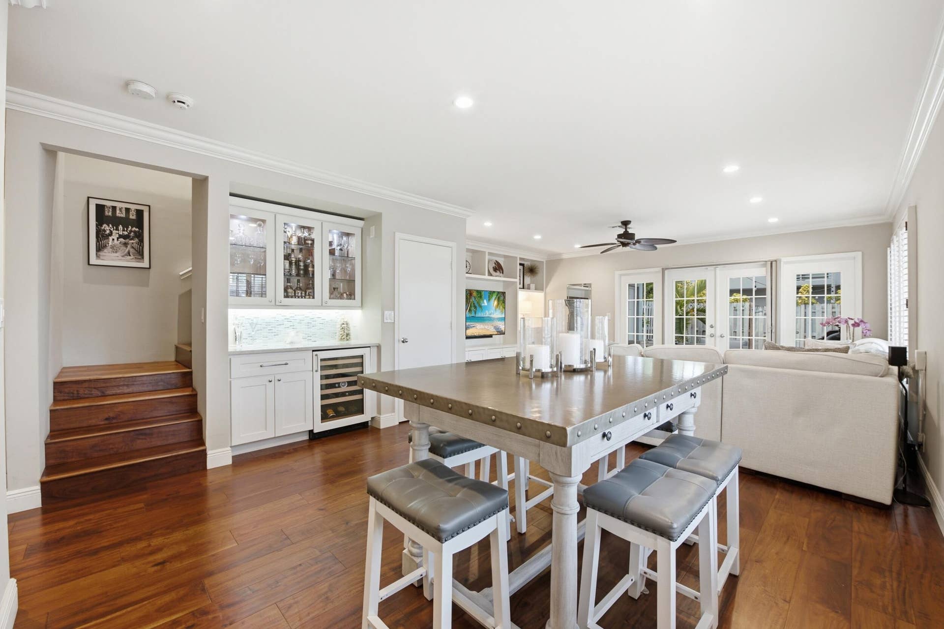 917 NE 3RD Street, #9, Fort Lauderdale, Fort Lauderdale, FL 33301 Open-concept living area featuring rich wood-finish flooring, a built-in wet bar with under-cabinet lighting and beverage cooler, recessed lighting, crown molding, and double French doors with sidelights
