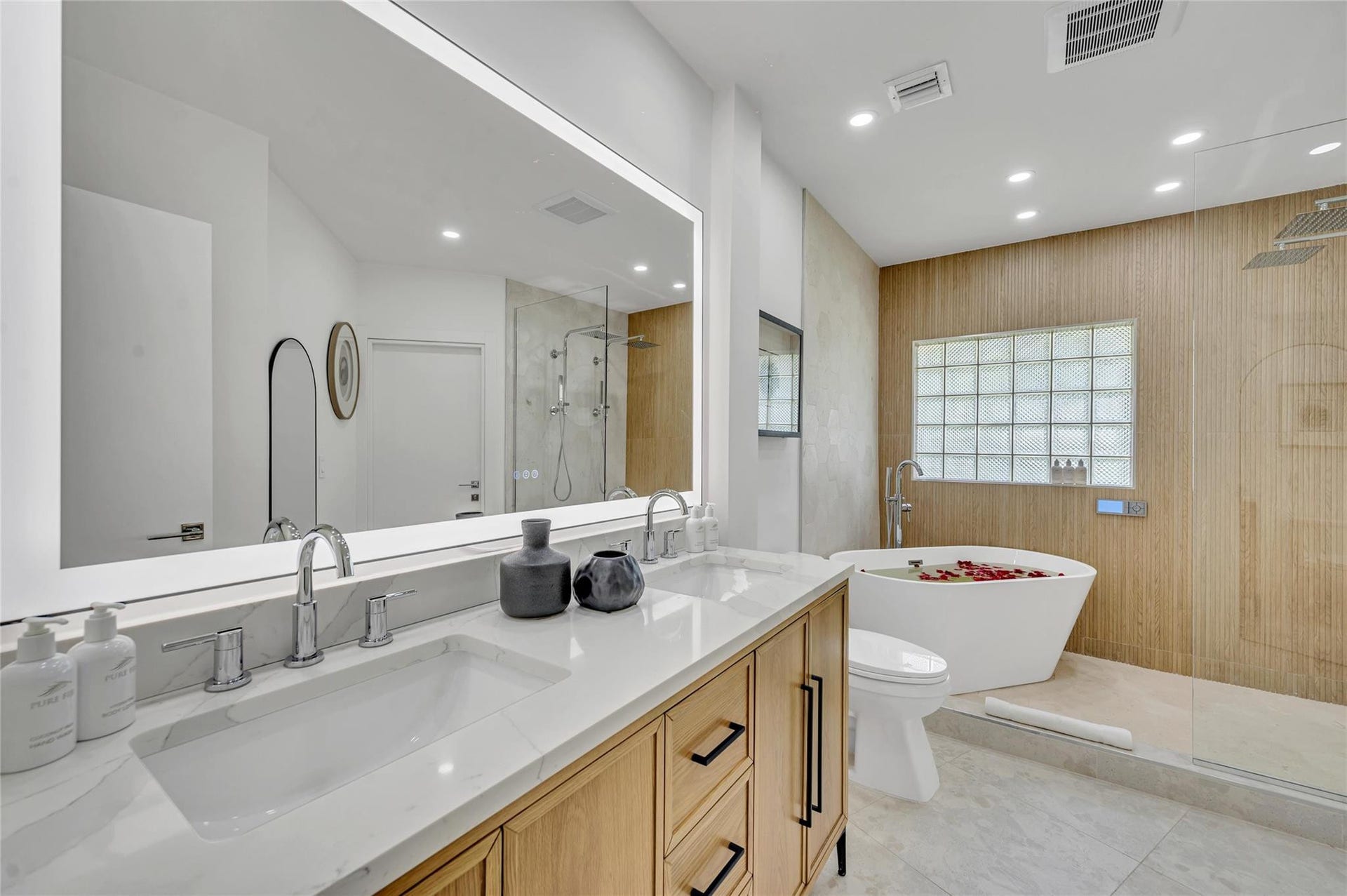 Spa-like master bathroom, Dual shower with Moen digital controls connected to high-end Delta Rainfall showerheads with separate handheld and soaking tub. Dual vanities, with lit mirror and power outlets in the vanity for hair driers etc.