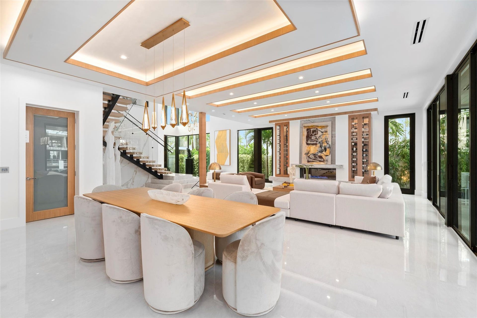 Surrounded by expansive windows, this elegant space is filled with natural light and showcases panoramic waterway views and lush tropical landscaping.