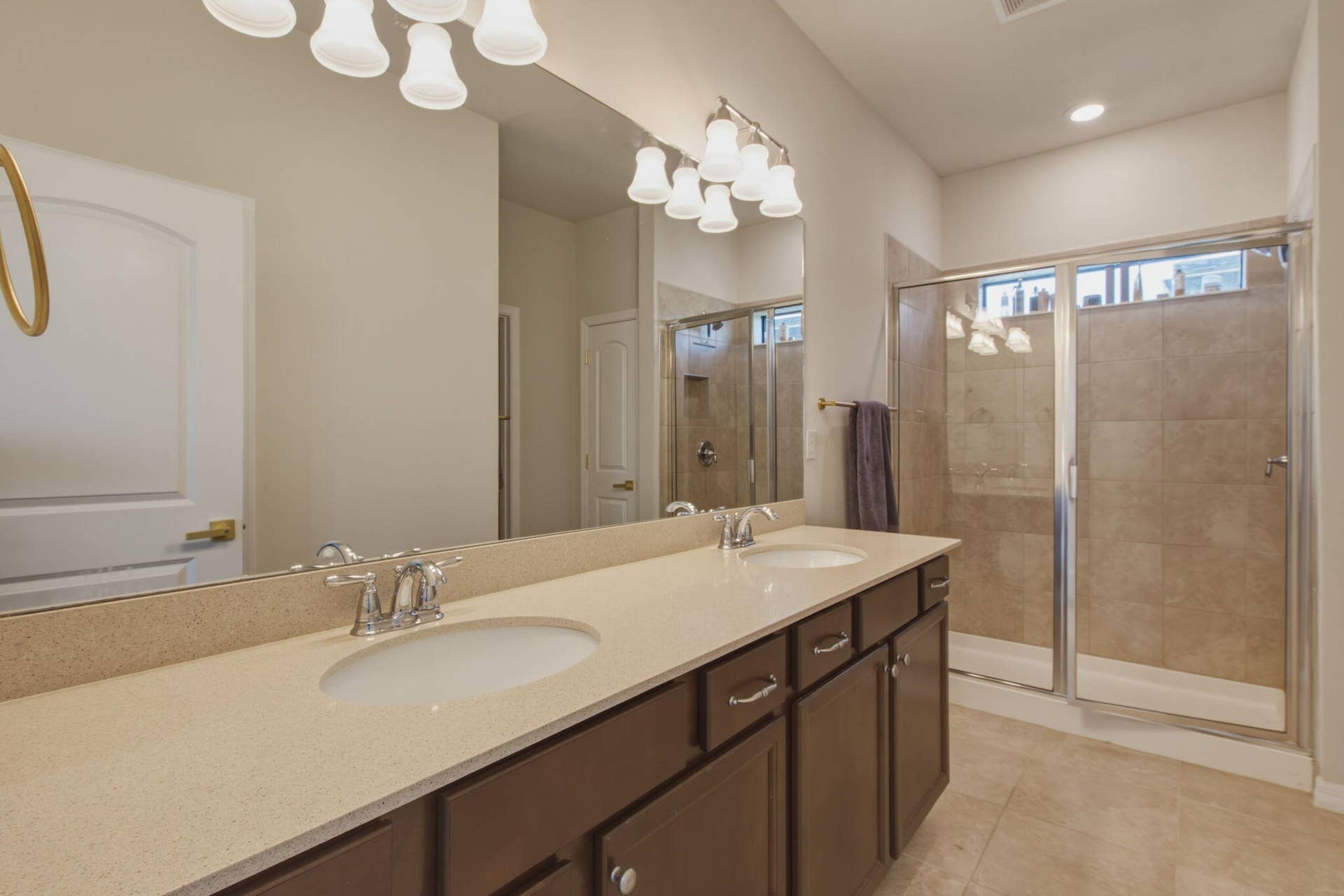 4601 Pinehurst Trail E, Oakland Park, FL 33309 Dual sink vanity with a light-colored countertop, dark wood-finish cabinetry, and chrome fixtures