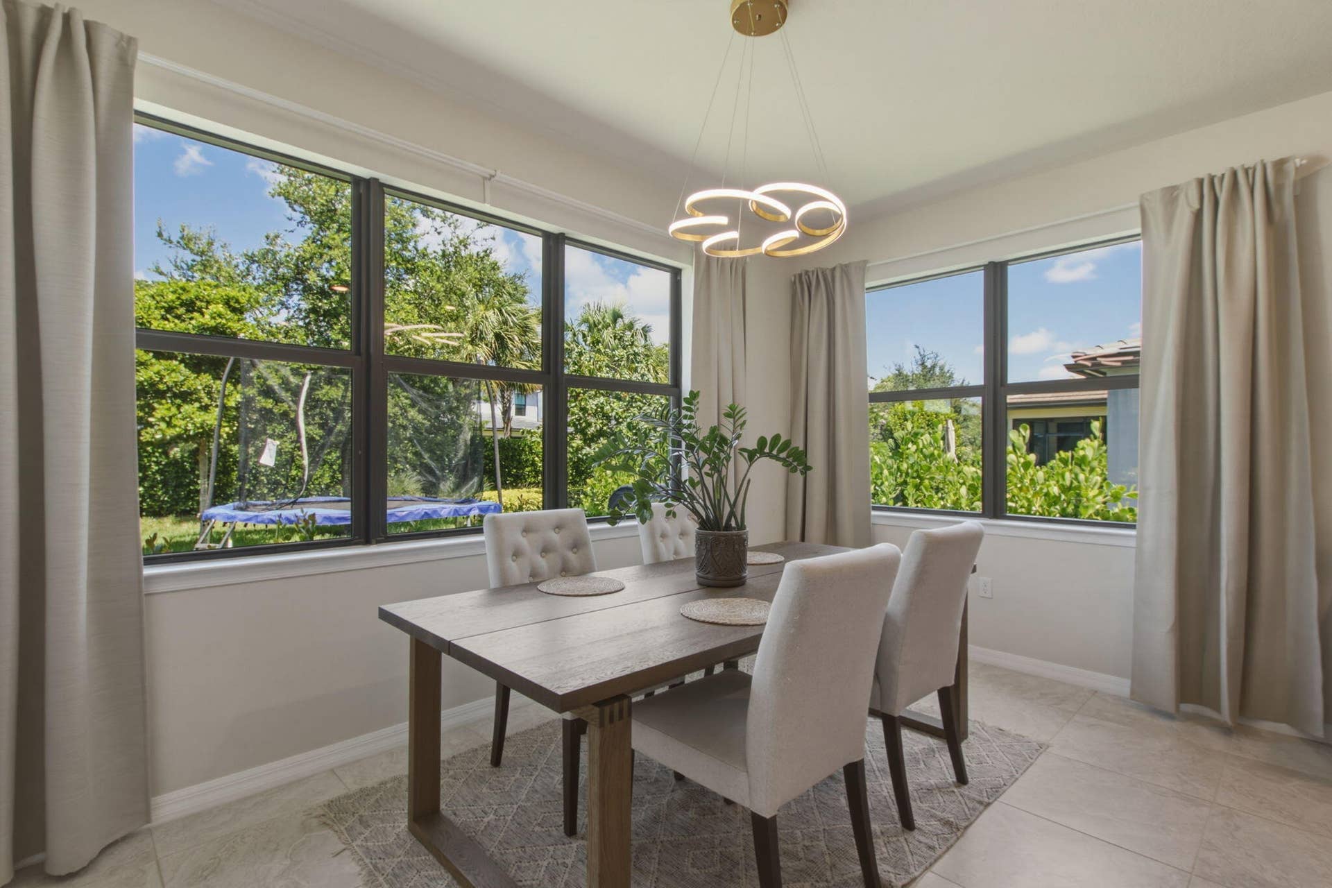 4601 Pinehurst Trail E, Oakland Park, FL 33309 Dining area featuring large windows, a contemporary light fixture, tiled flooring, and neutral wall tones