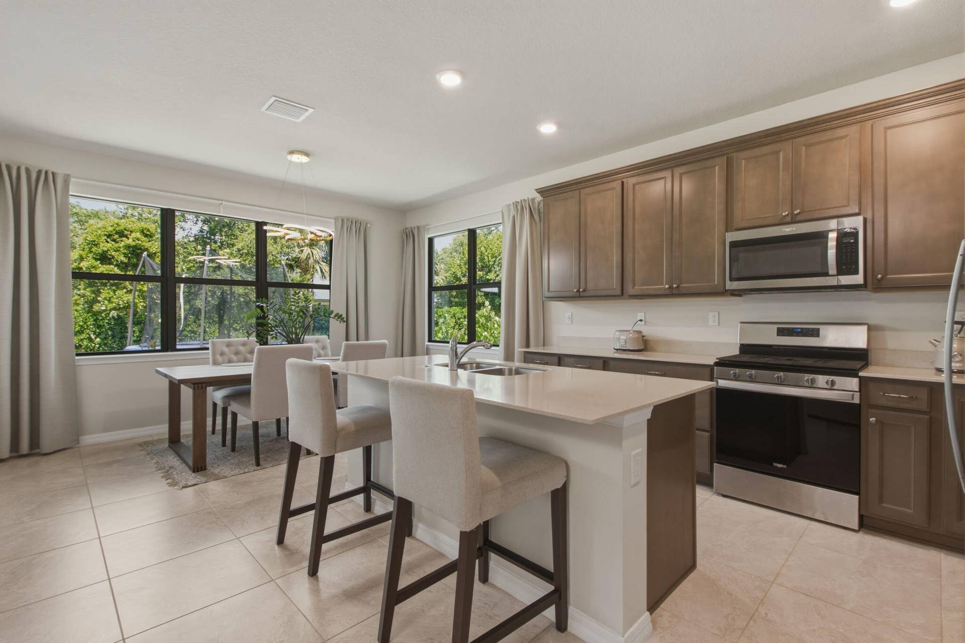 4601 Pinehurst Trail E, Oakland Park, FL 33309 Open-concept kitchen and dining area featuring light-toned tile flooring, recessed lighting, and expansive windows