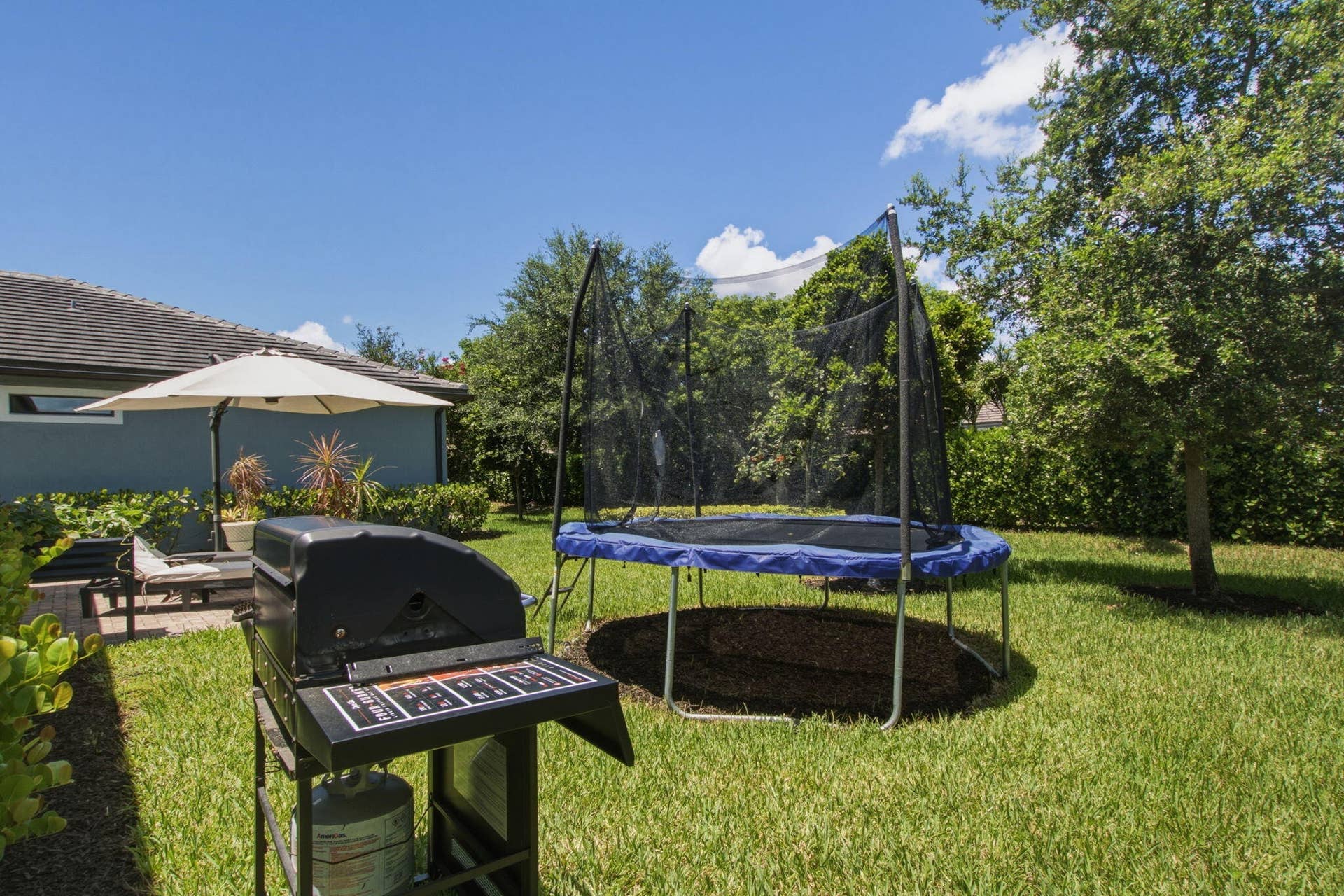 4601 Pinehurst Trail E, Oakland Park, FL 33309 Expansive backyard featuring a manicured lawn, established trees, and a paver patio area