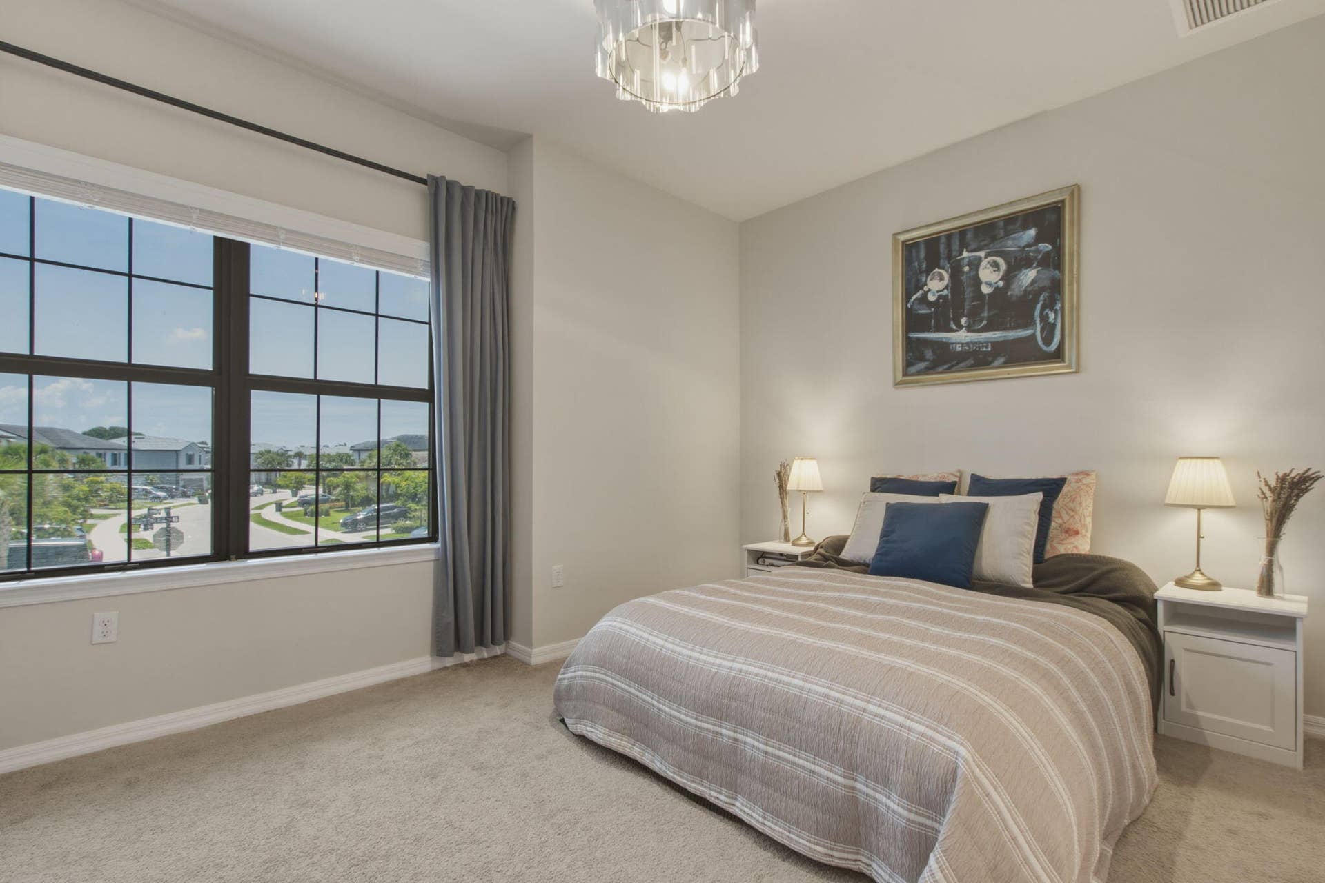 4601 Pinehurst Trail E, Oakland Park, FL 33309 Spacious bedroom featuring neutral carpeting and a large grid-pattern window with a streetscape beyond