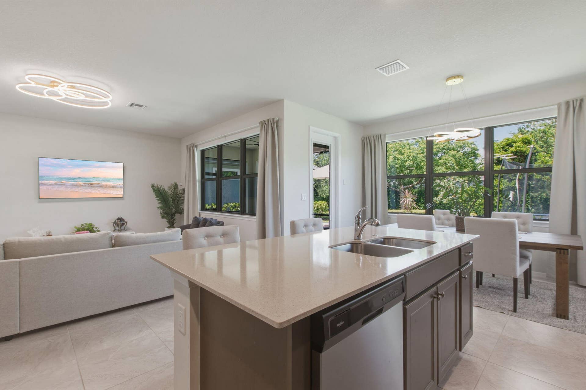 4601 Pinehurst Trail E, Oakland Park, FL 33309 Kitchen island featuring a dual-basin stainless steel sink, integrated dishwasher, and light-toned countertop