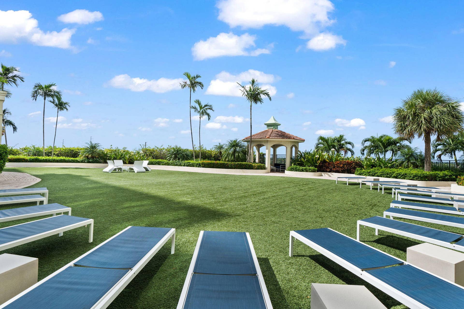 610 W Las Olas Boulevard, #115N, Fort Lauderdale, FL 33312 Resort-style pool deck with chaise lounges, open lawn space, cabanas & tropical landscaping.