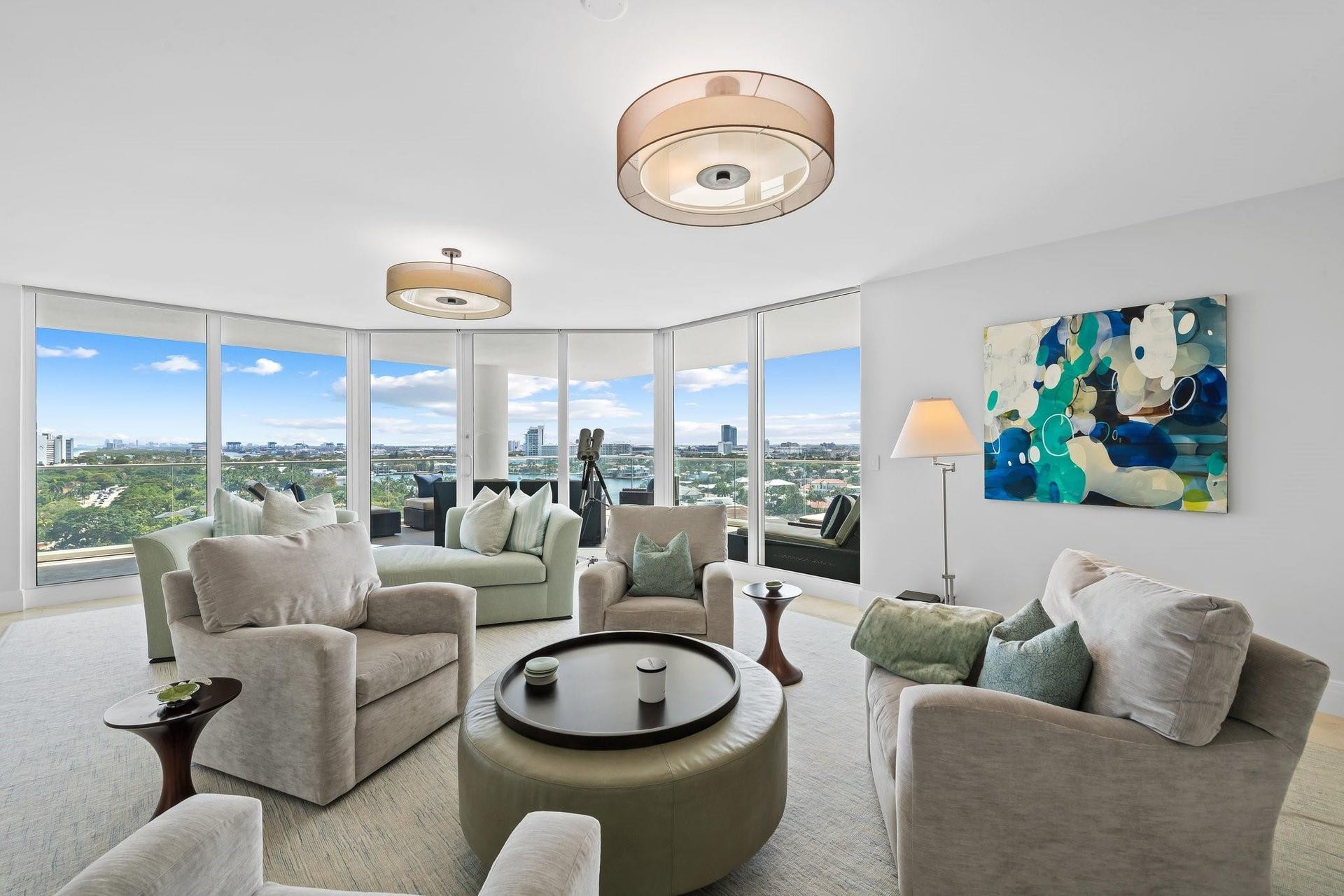 3055 Harbor Drive, #1403, Fort Lauderdale, FL 33316 Spacious living area featuring floor-to-ceiling windows, panoramic urban and greenbelt scenery, recessed lighting, and elegant wood-finish flooring