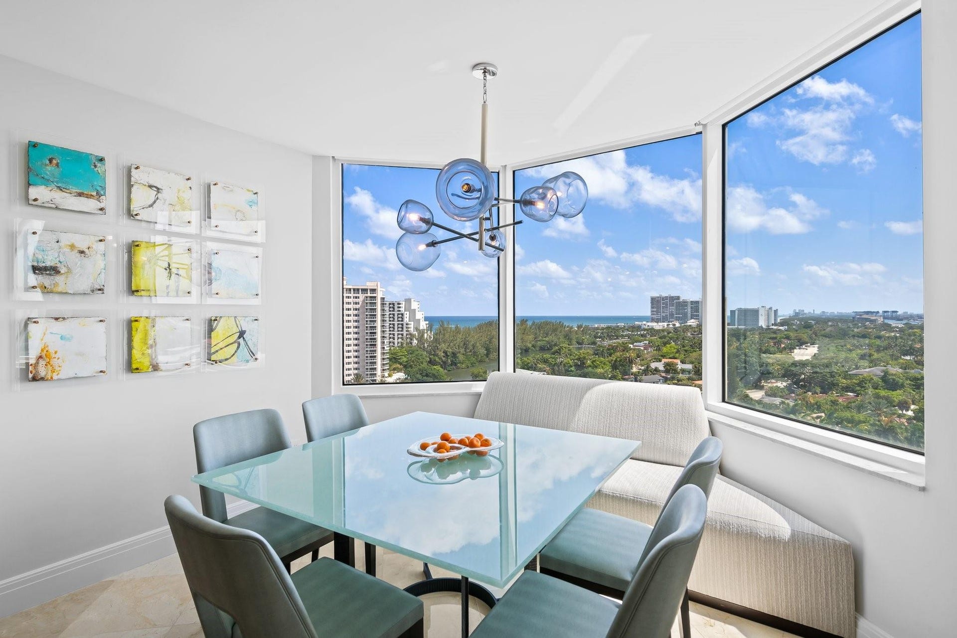 3055 Harbor Drive, #1403, Fort Lauderdale, FL 33316 Dining area featuring expansive floor-to-ceiling windows, a built-in banquette, and a modern chandelier