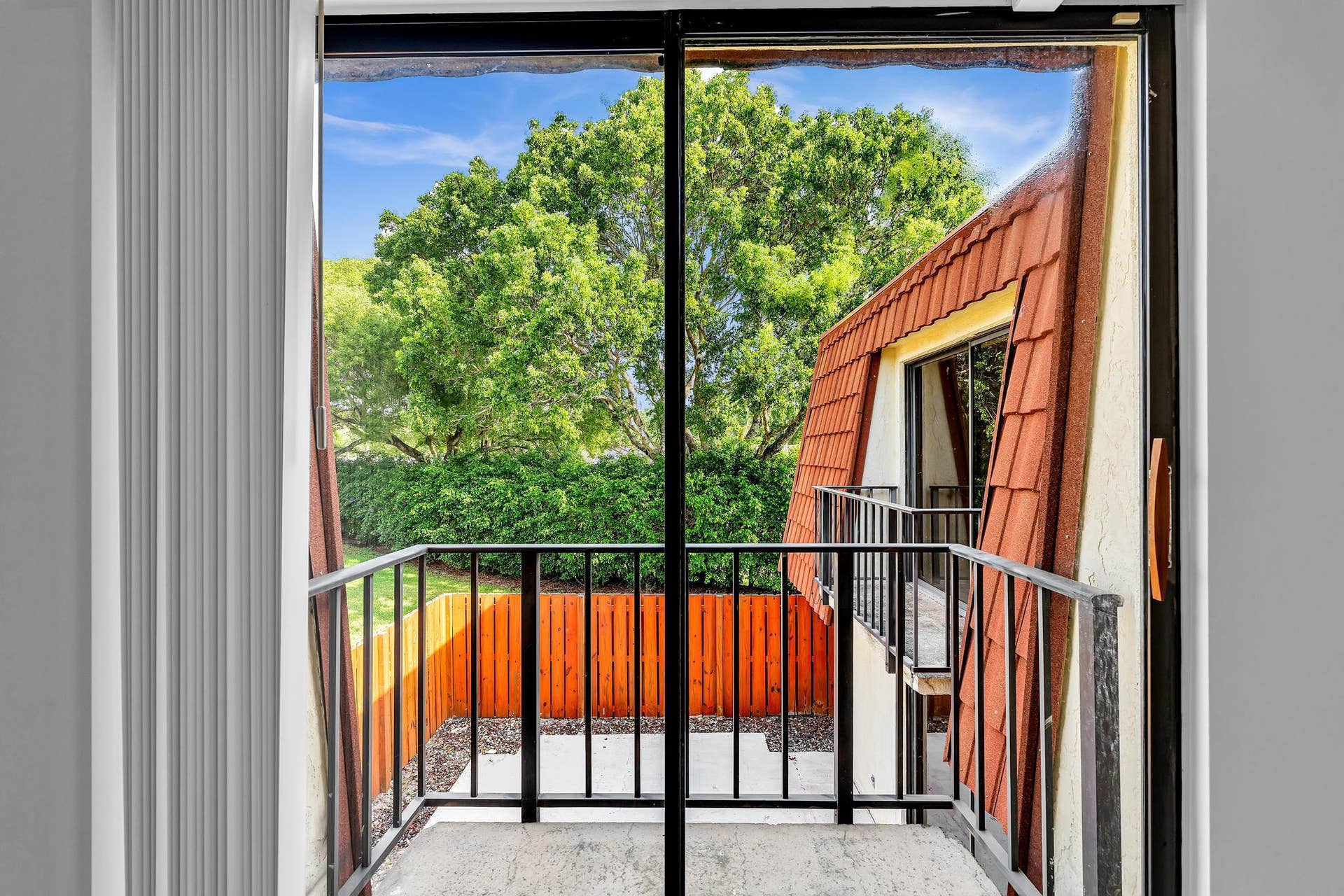 Sliding glass door leading to a private outdoor balcony with black metal railings