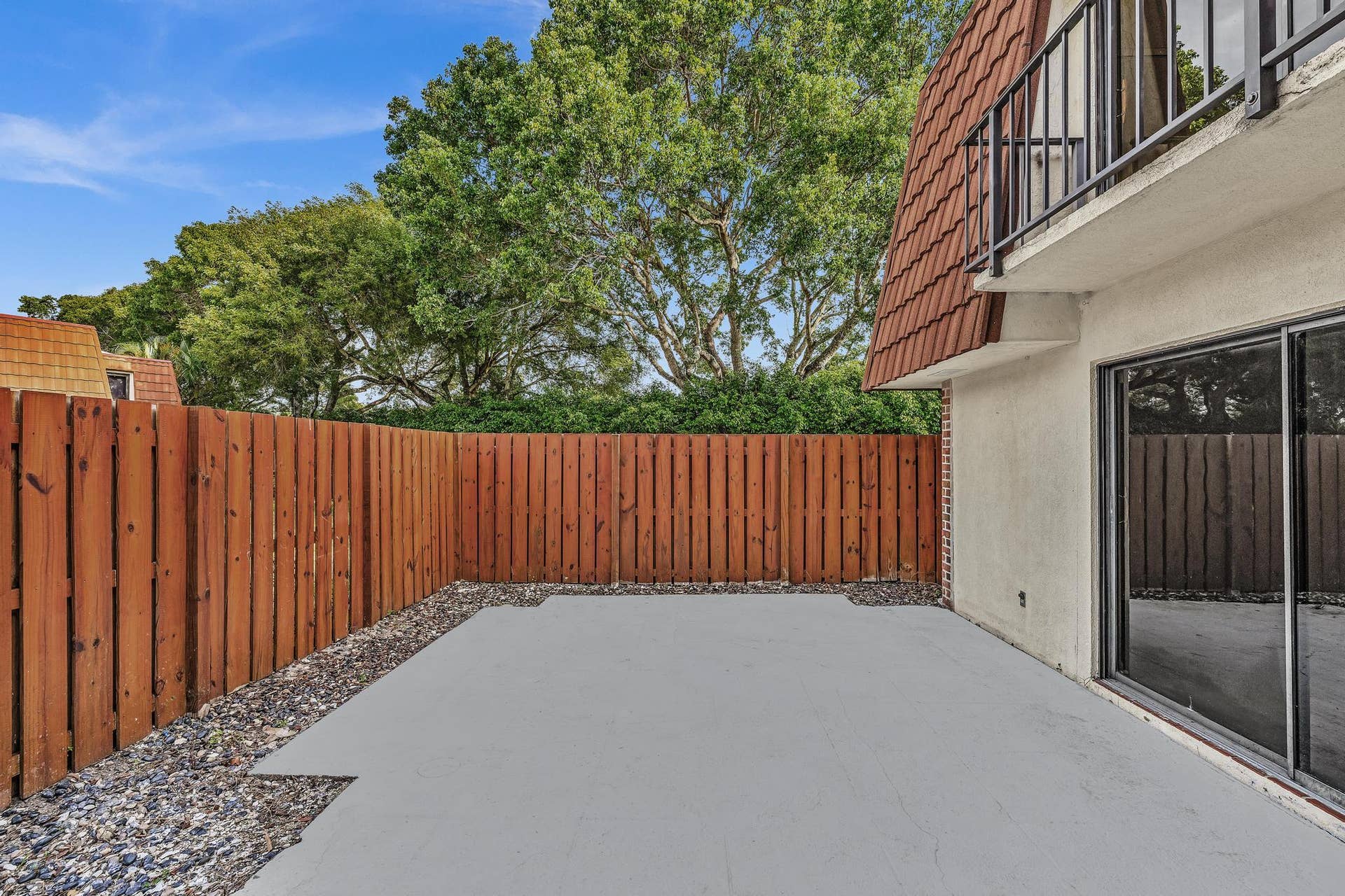 Private patio with concrete surfacing and surrounding gravel accents