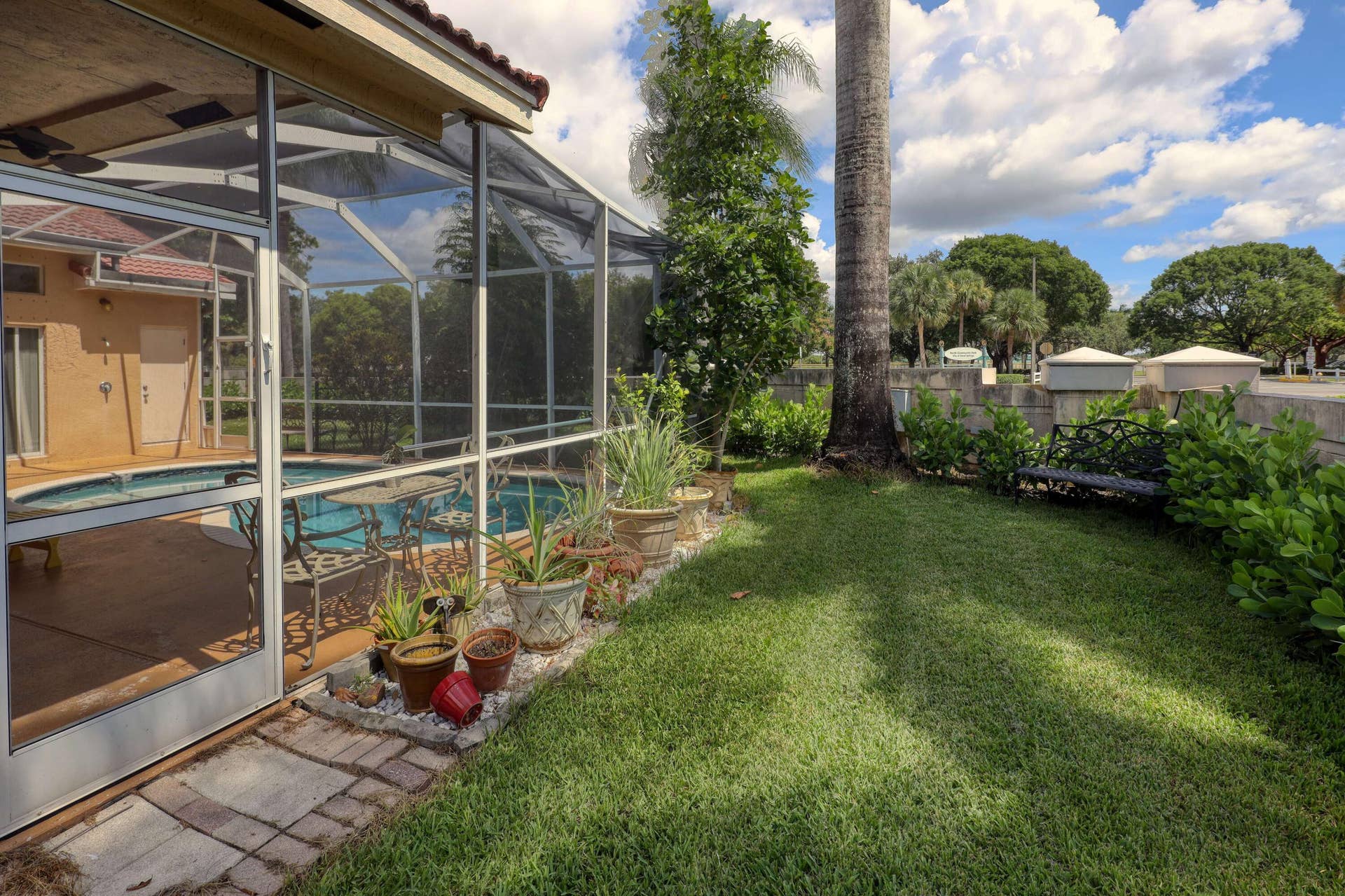 Private fenced backyard with screened pool enclosure, green space, and room for pets or outdoor activities.