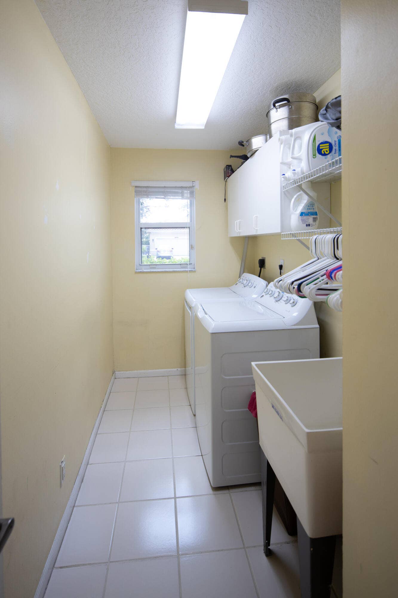 Separate laundry room with utility sink, storage space, and newer washer and dryer for added convenience.