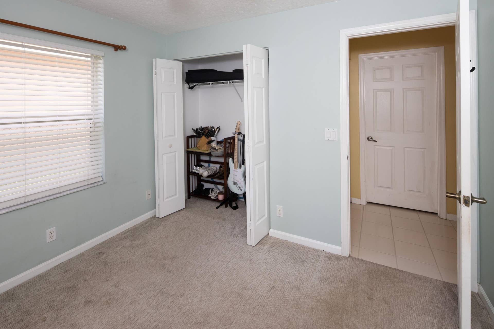 Bright third bedroom with ample closet space and flexible use for family, guests, or a home office.