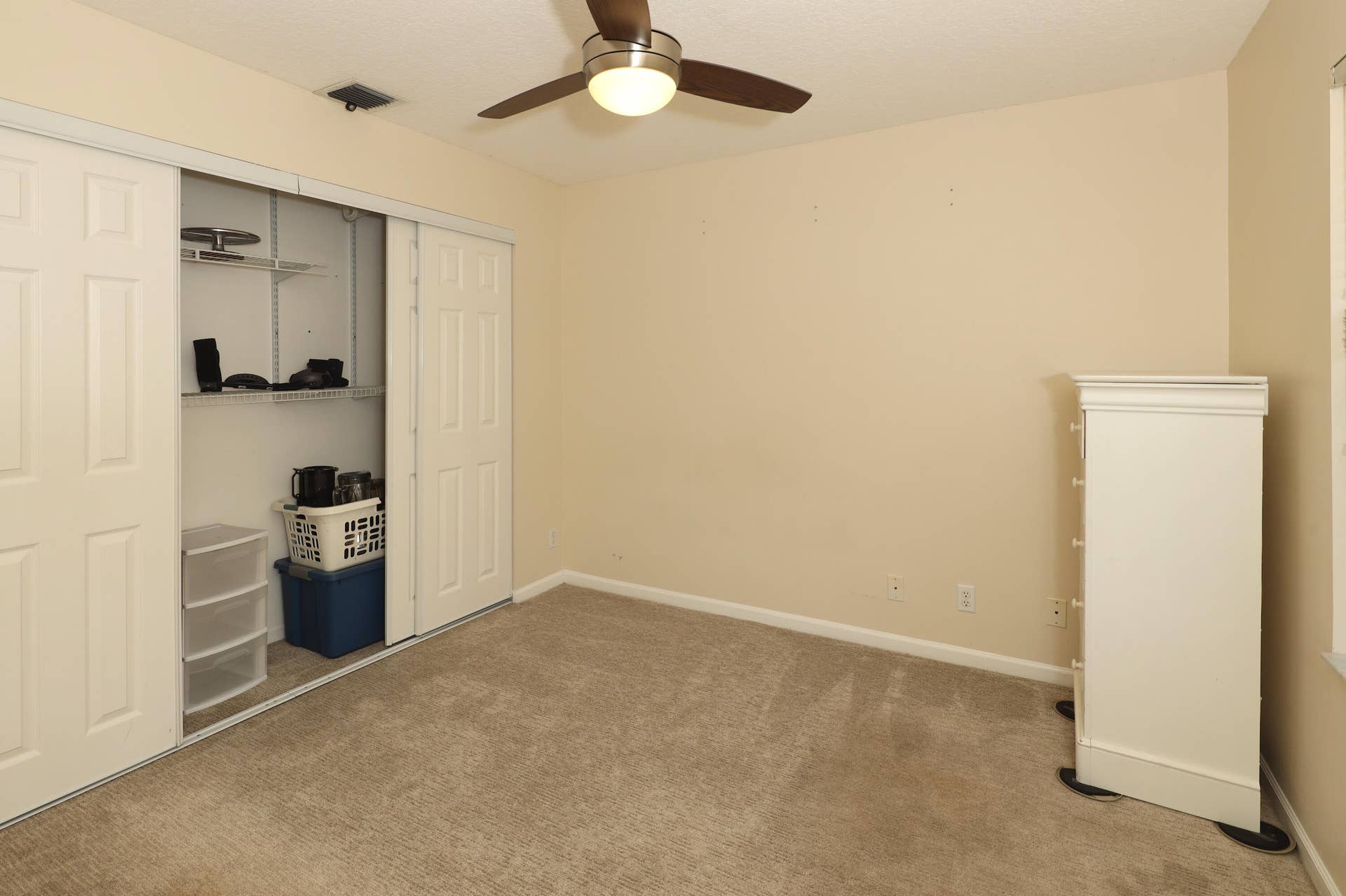 Spacious secondary bedroom with large closet and plenty of natural light, ideal for family or guests.