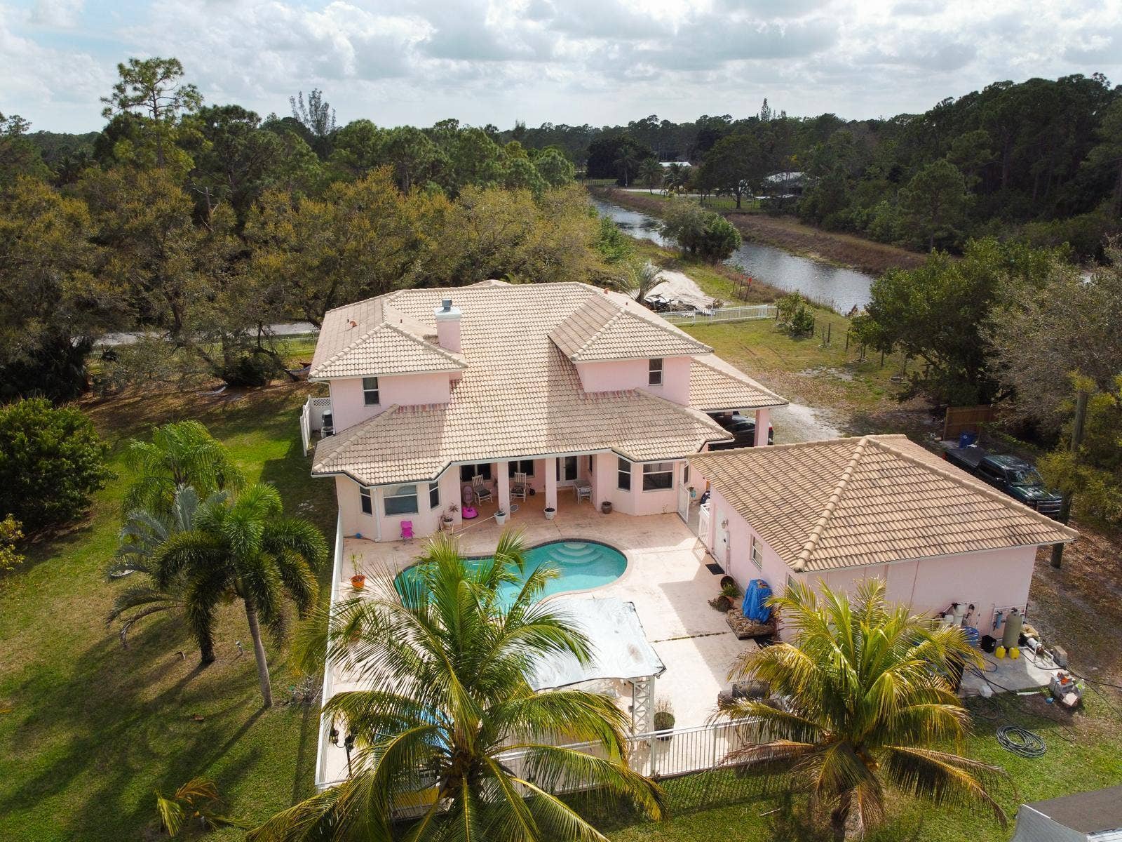 Expansive property featuring a multi-level residence with a tile roof and a separate detached structure