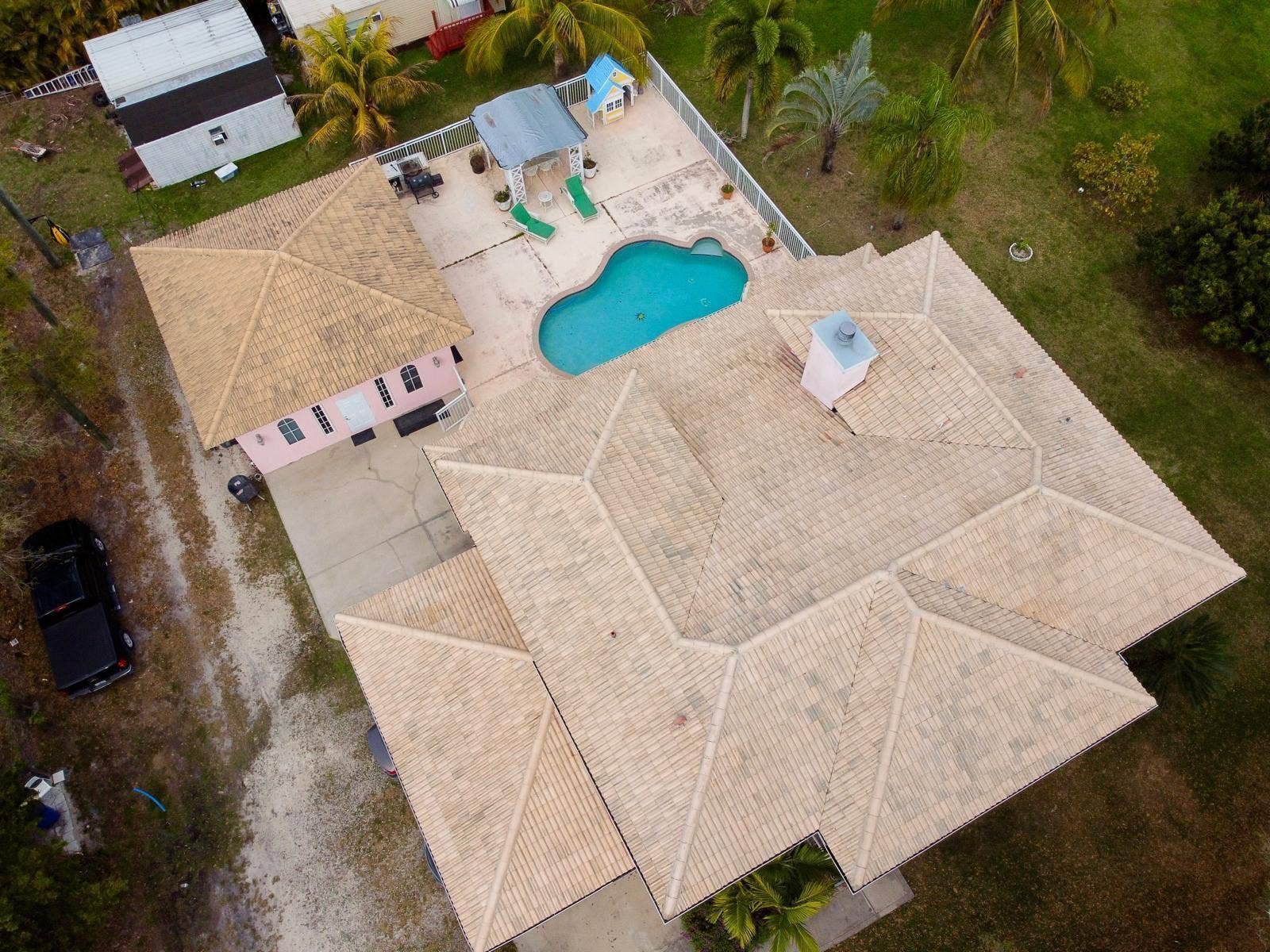 Expansive property featuring a large main residence with a multi-gabled tile roof and a separate structure with a matching tile roof
