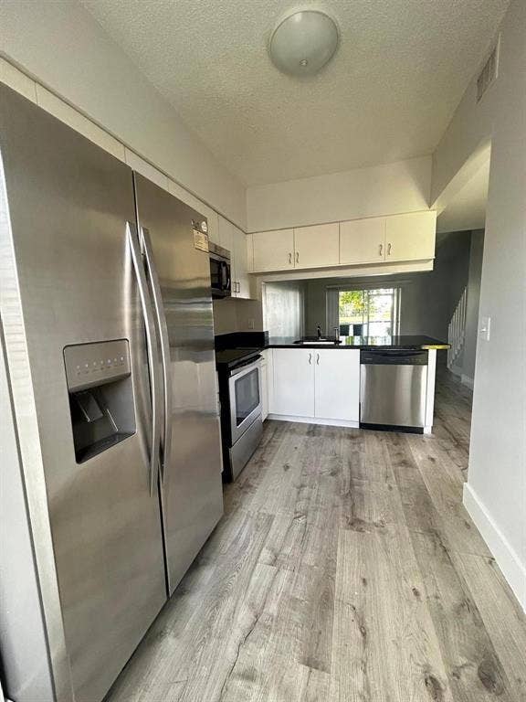 Kitchen featuring stainless steel appliances including a refrigerator with water/ice dispenser, range, and dishwasher