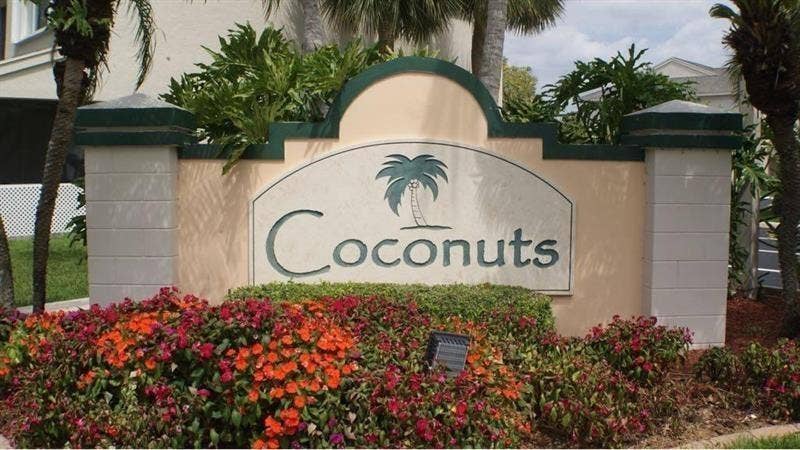 Decorative stone monument sign featuring a curved arch, a textured finish, and integrated planters
